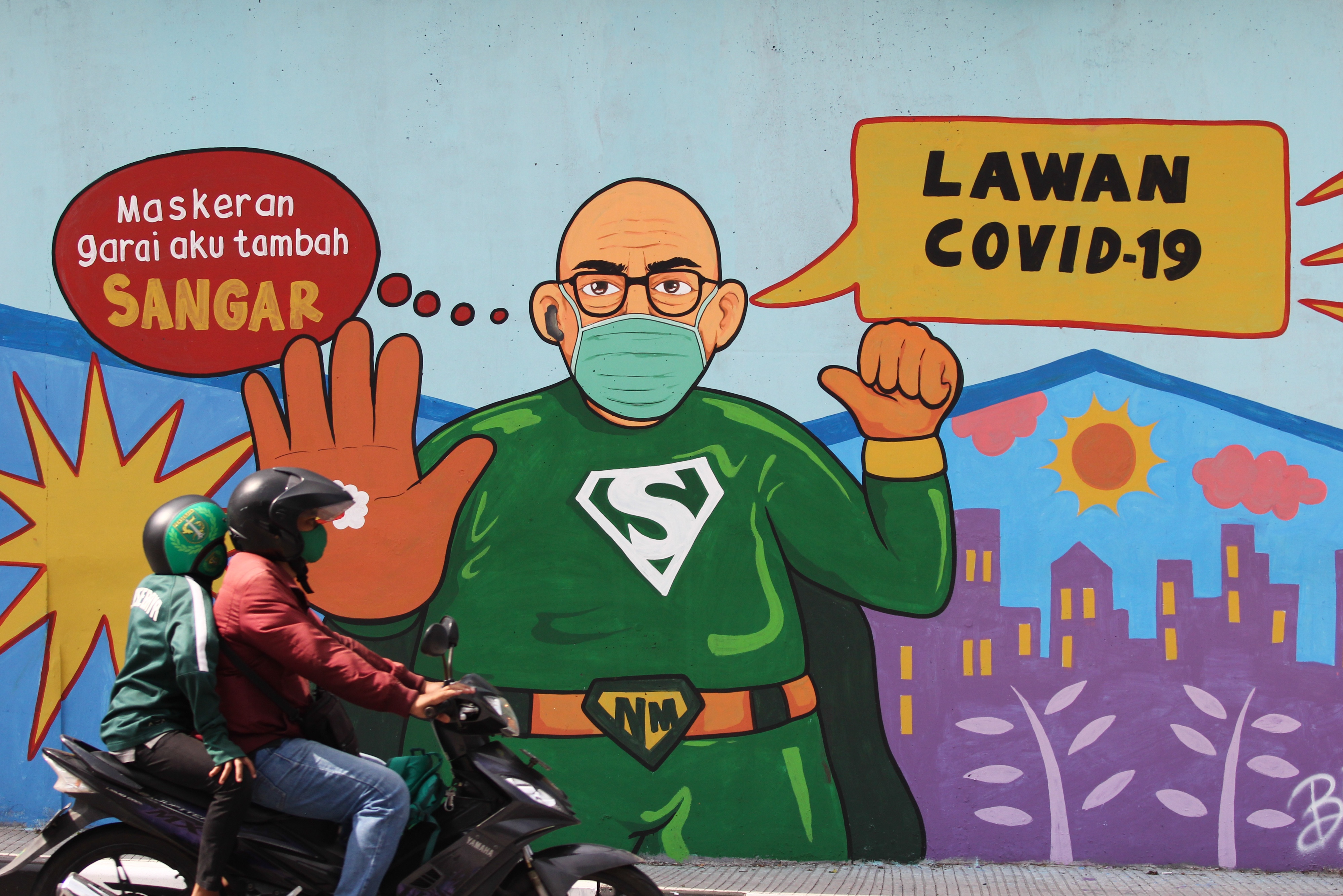 Pengendara sepeda motor melintas di dekat dinding bermural di terowongan Mayjen Sungkono, Surabaya, Jawa Timur.