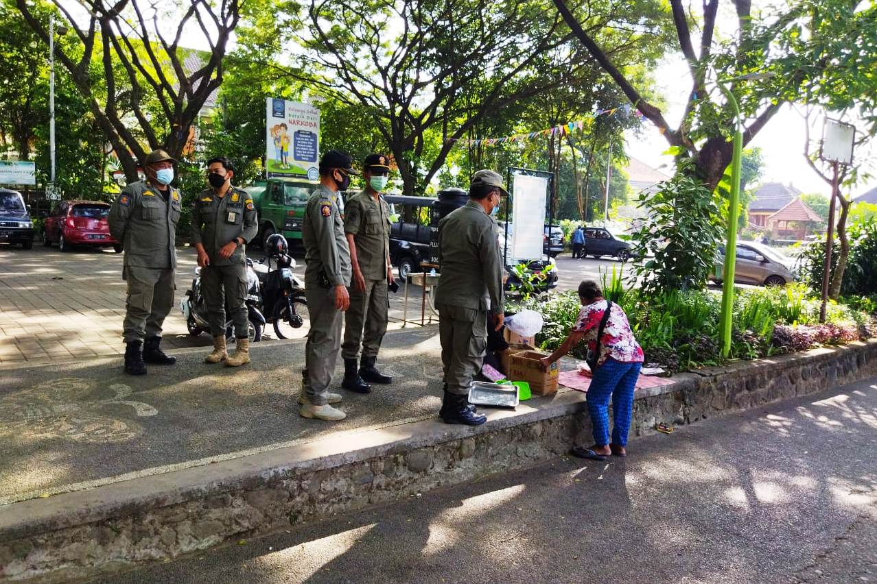Satpol PP Kota Denpasar yang tergabung dalam Tim Yustisi melakukan penertiban penerapan prokes di Lapangan Puputan.