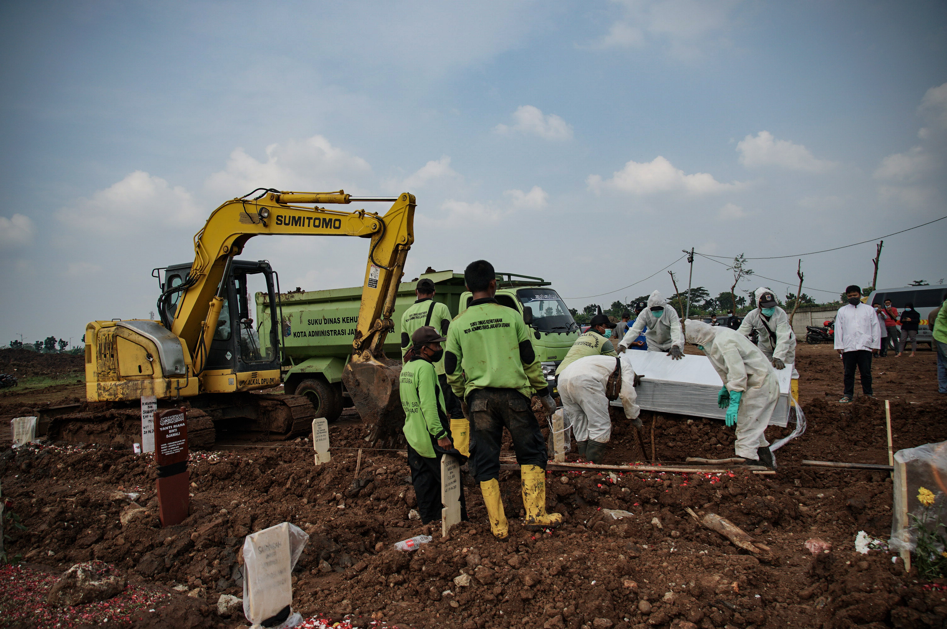Petugas memakamkan jenazah pasien covid-19 di TPU Rorotan, Cilincing, Jakarta.