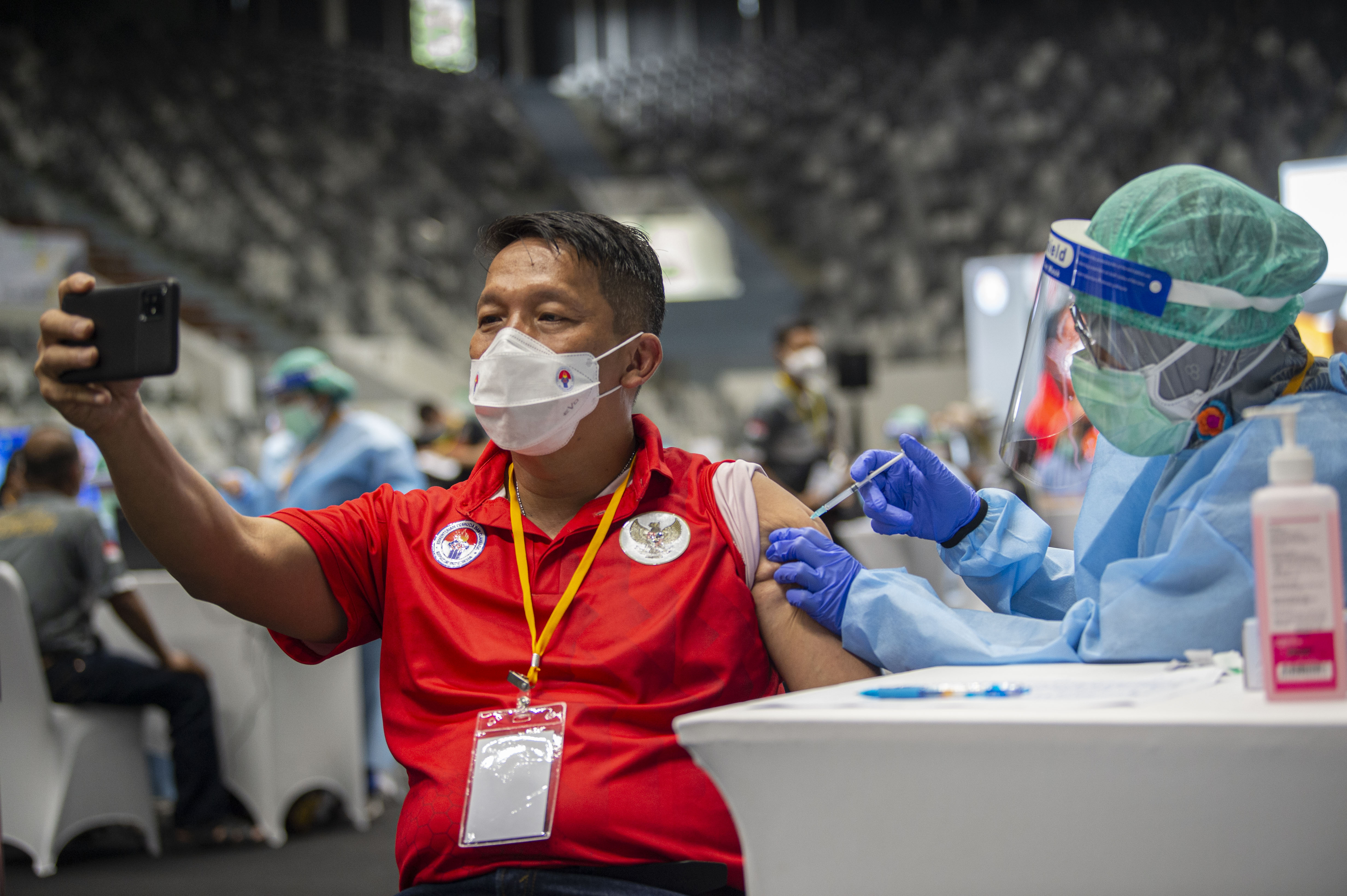Petugas menyuntikkan vaksin covid-19 pada Kepala Pelatih Timnas Angkat Besi Dirja Wihardja di Gelora Bung Karno, Jakarta, Jumat (26/2/2021).
