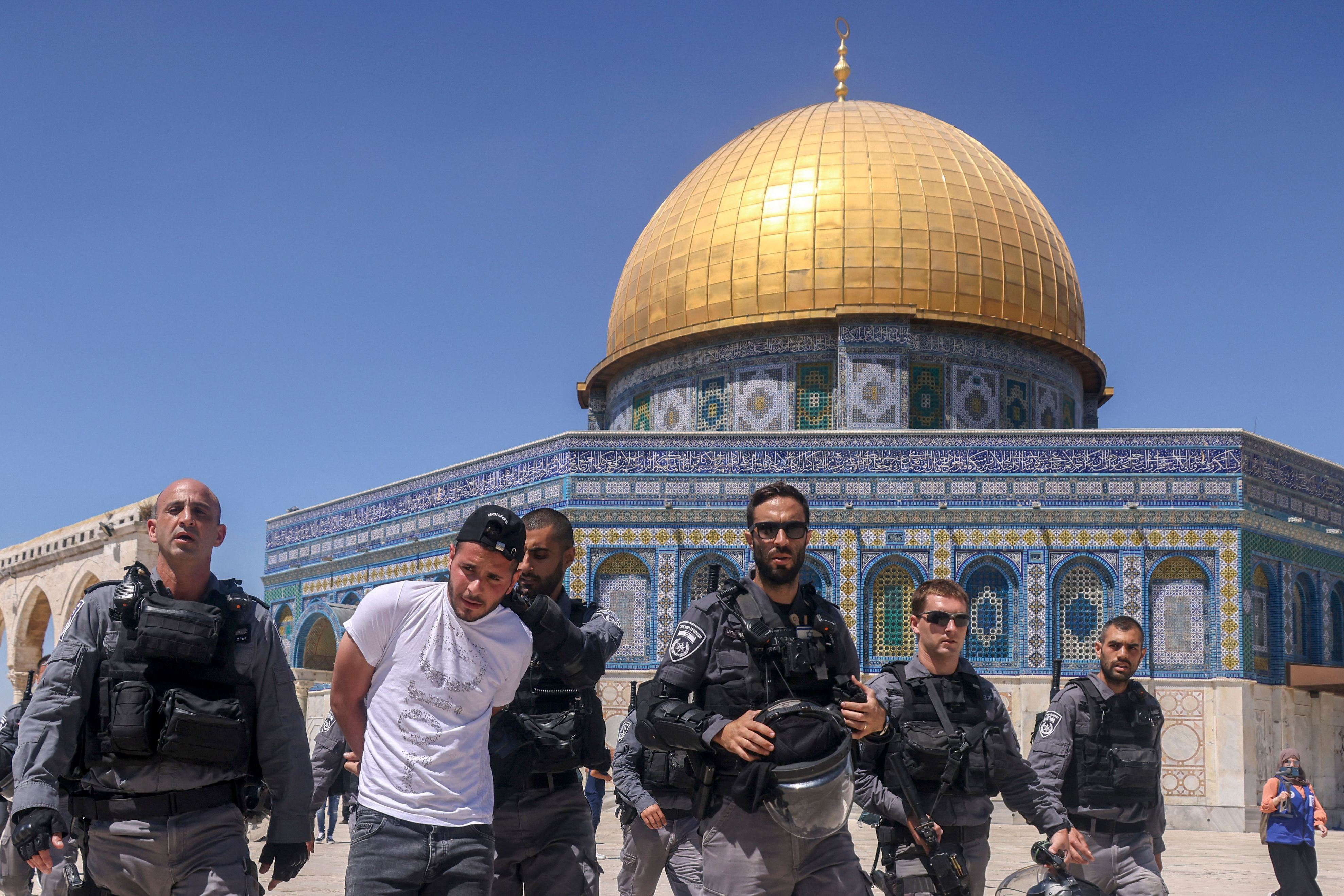 Pasukan keamanan Israel menahan pria Palestina di depan masjid Al-Aqsa setelah salat Jumat (18/6).