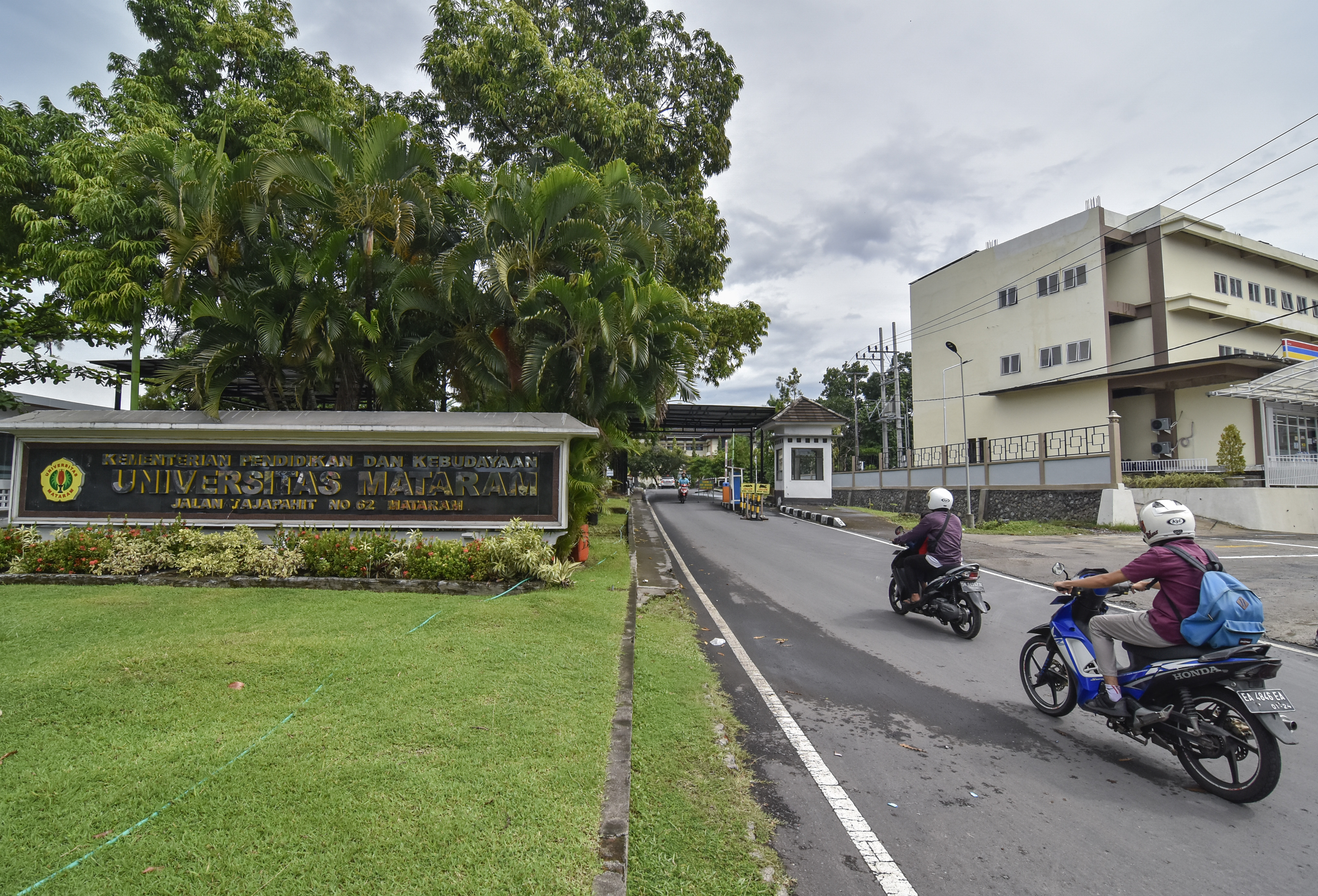 Mahasiswa mengendarai melintas di depan gerbang kampus Universitas Mataram (Unram) di Mataram, NTB, Selasa (19/1/2021).