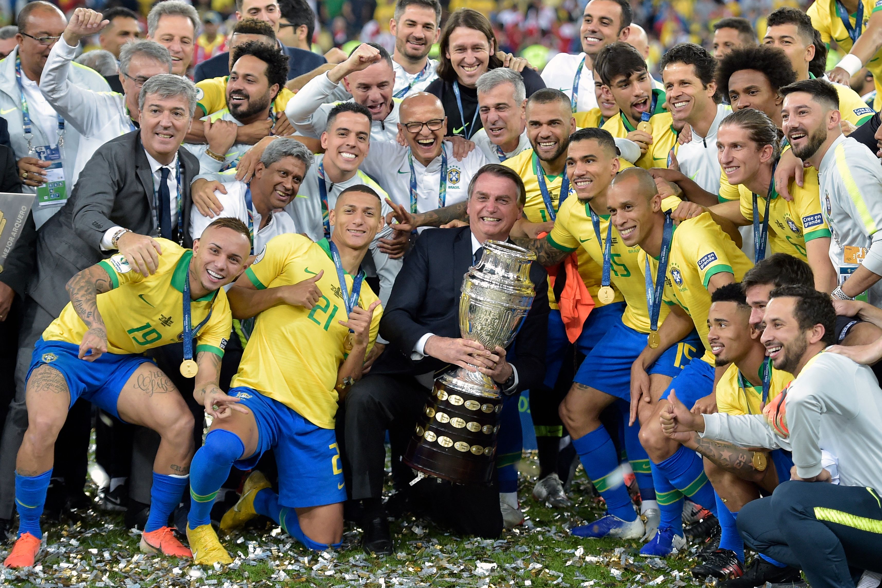 Presiden Jair Bolsonaro (tengah) berpose dengan timnas Brasil yang menjuarai Copa America, 7 Juli 2019 lalu.
