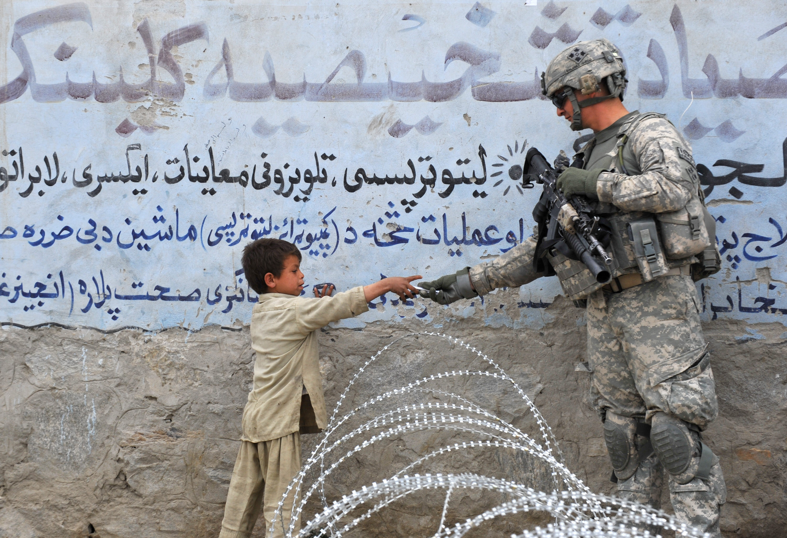 Seorang personel militer AS berinteraksi dengan seorang anak Afghanistan di Khogiani, Langarhar, Afghanistan.