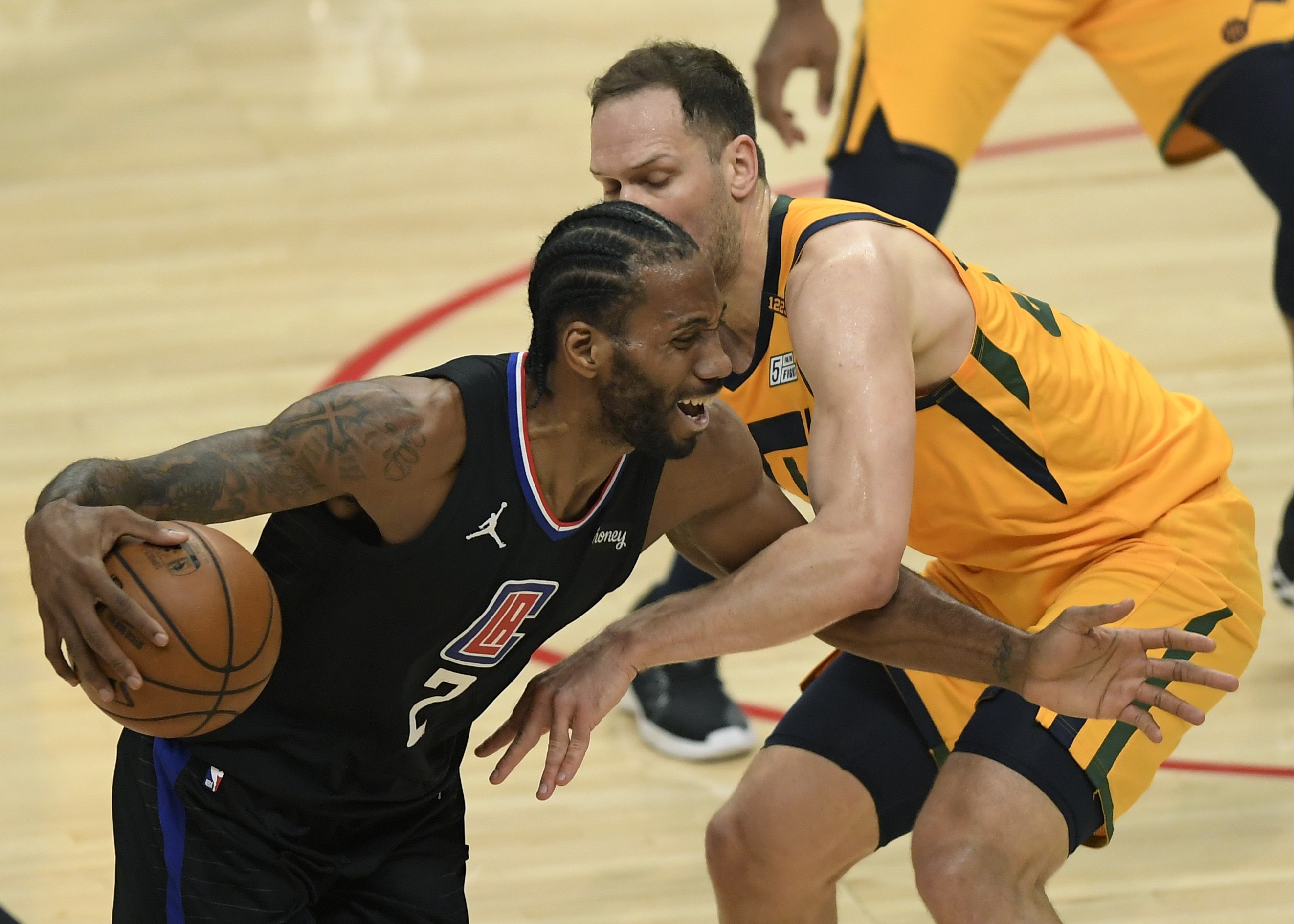 Bintang Los Angeles Clippers, Kawhi Leonard (kiri), mencoba melepas dari hadangan pemain Utah Jazz, Bojan Bogdanovic.