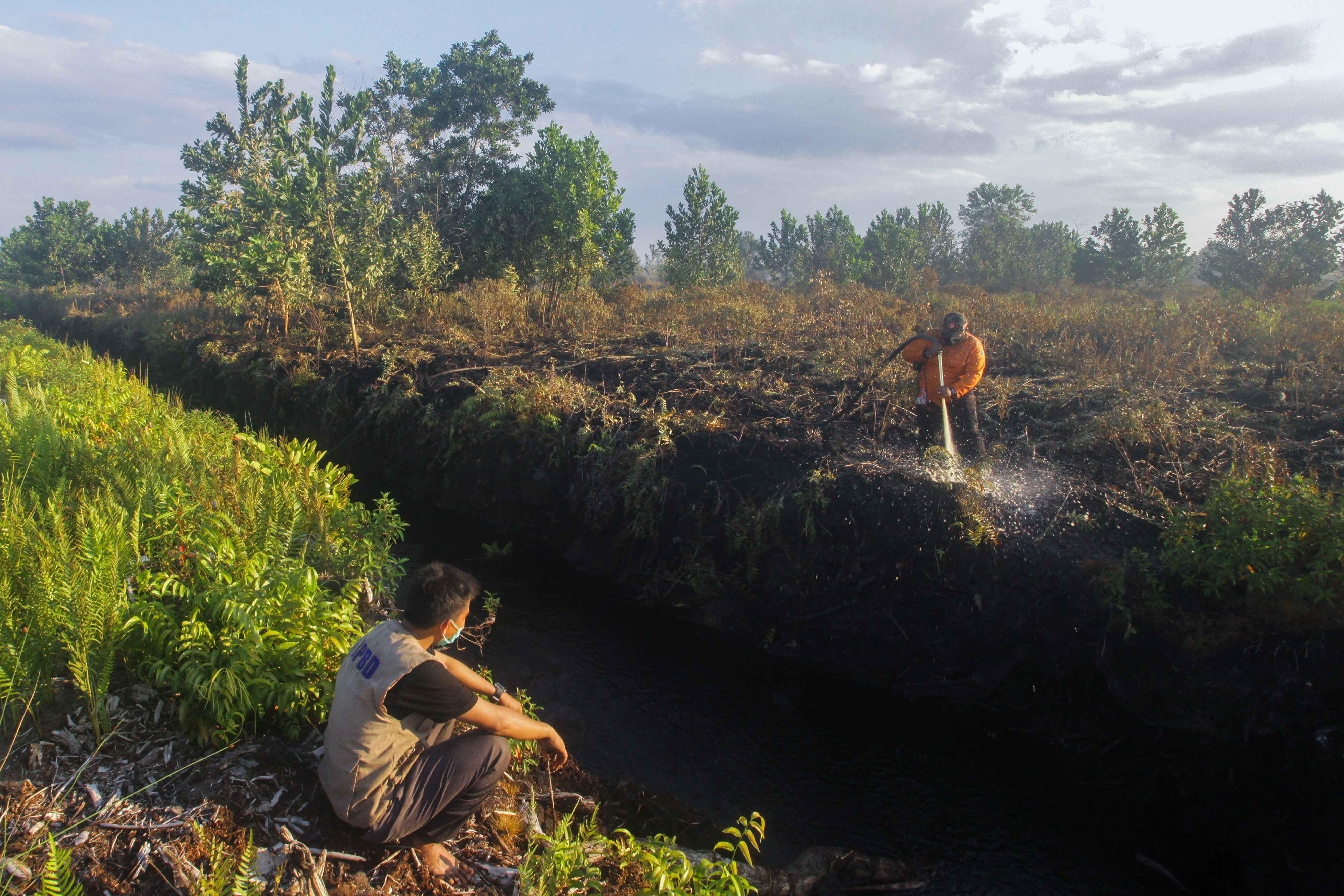 PEMADAMAN KARHUTLA: Petugas melakukan proses pendinginan lahan gambut yang terbakar di wilayah Palangkaraya, Kalimantan Tengah, Sabtu (24/4)