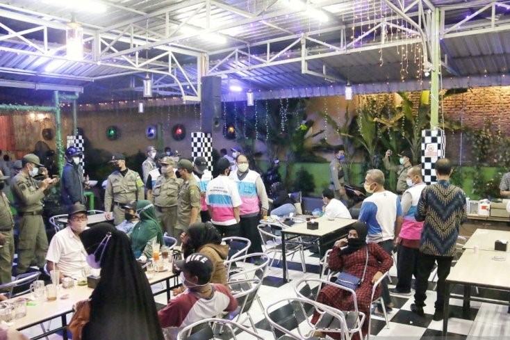 Sejumlah petugas tim Pemkot Medan membubarkan pengunjung salah satu cafe terletak di Jalan HM Joni, Medan