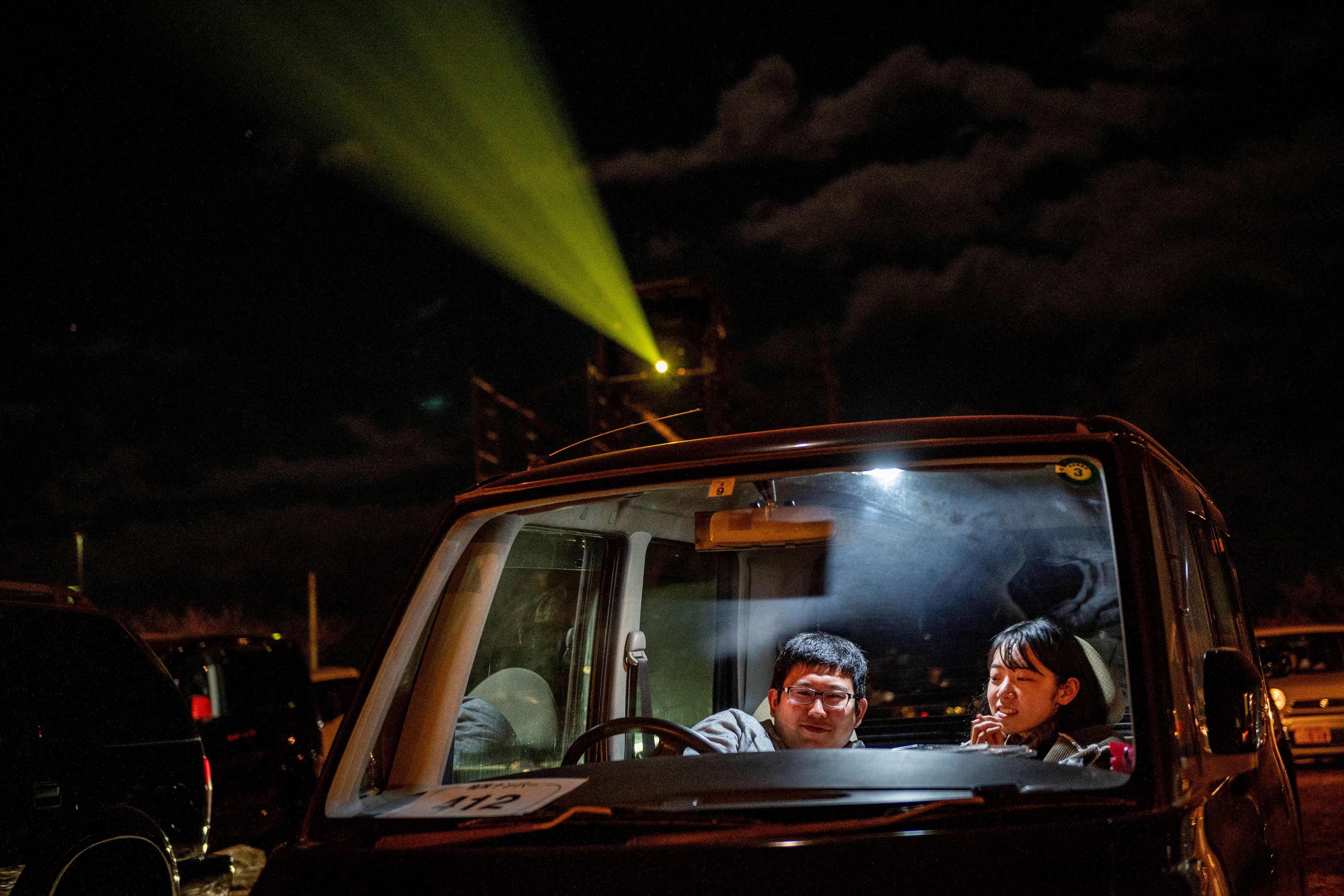 Pengunjung dalam mobil mereka saat menonton film di bioskop drive-in, Nagai Seaside Park di Yokosuka, prefektur Kanagawa, selatan Tokyo.