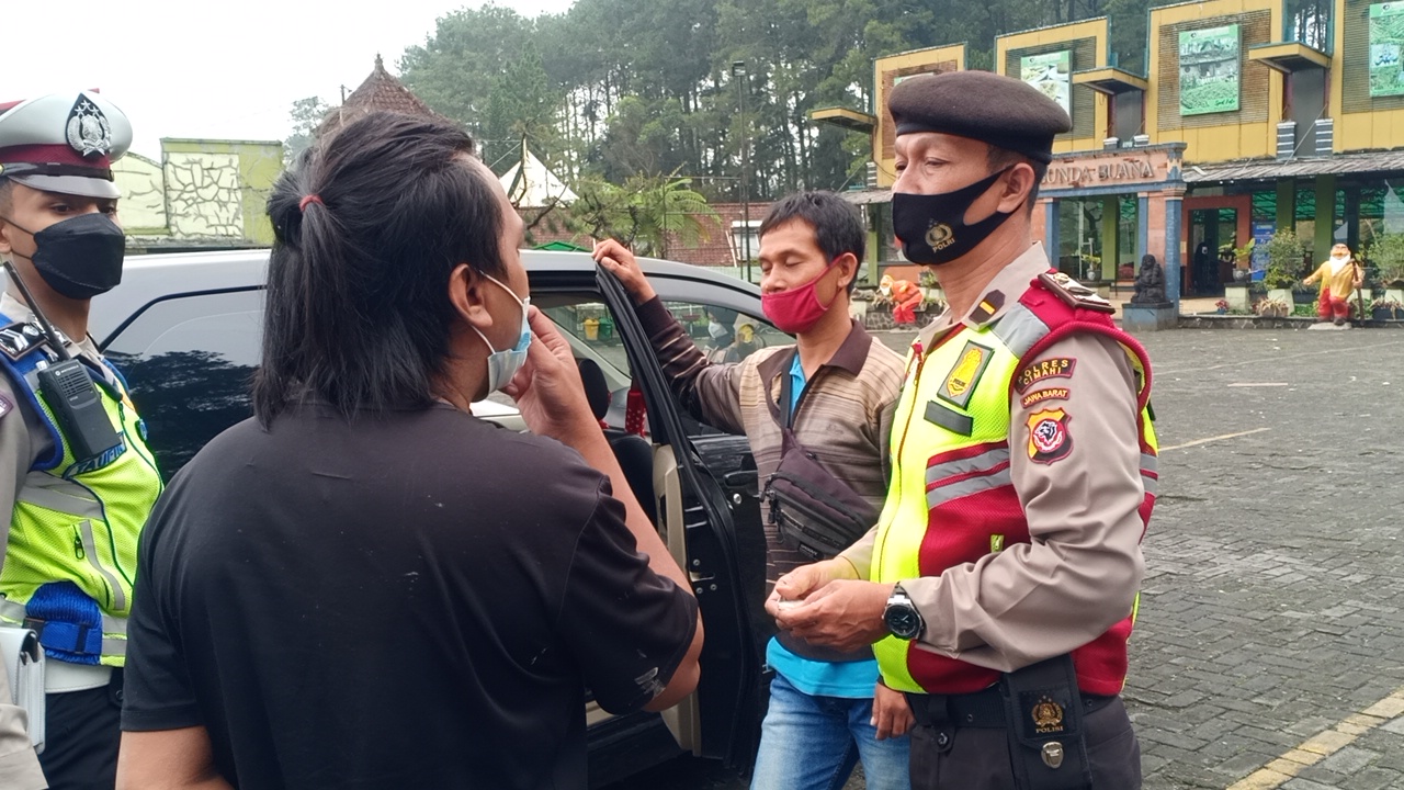 Anggota polisi memeriksa pendatang saat operasi penyekatan di Grafika Cikole Lembang Kabupaten Bandung Barat, Sabtu (19/6/2021)