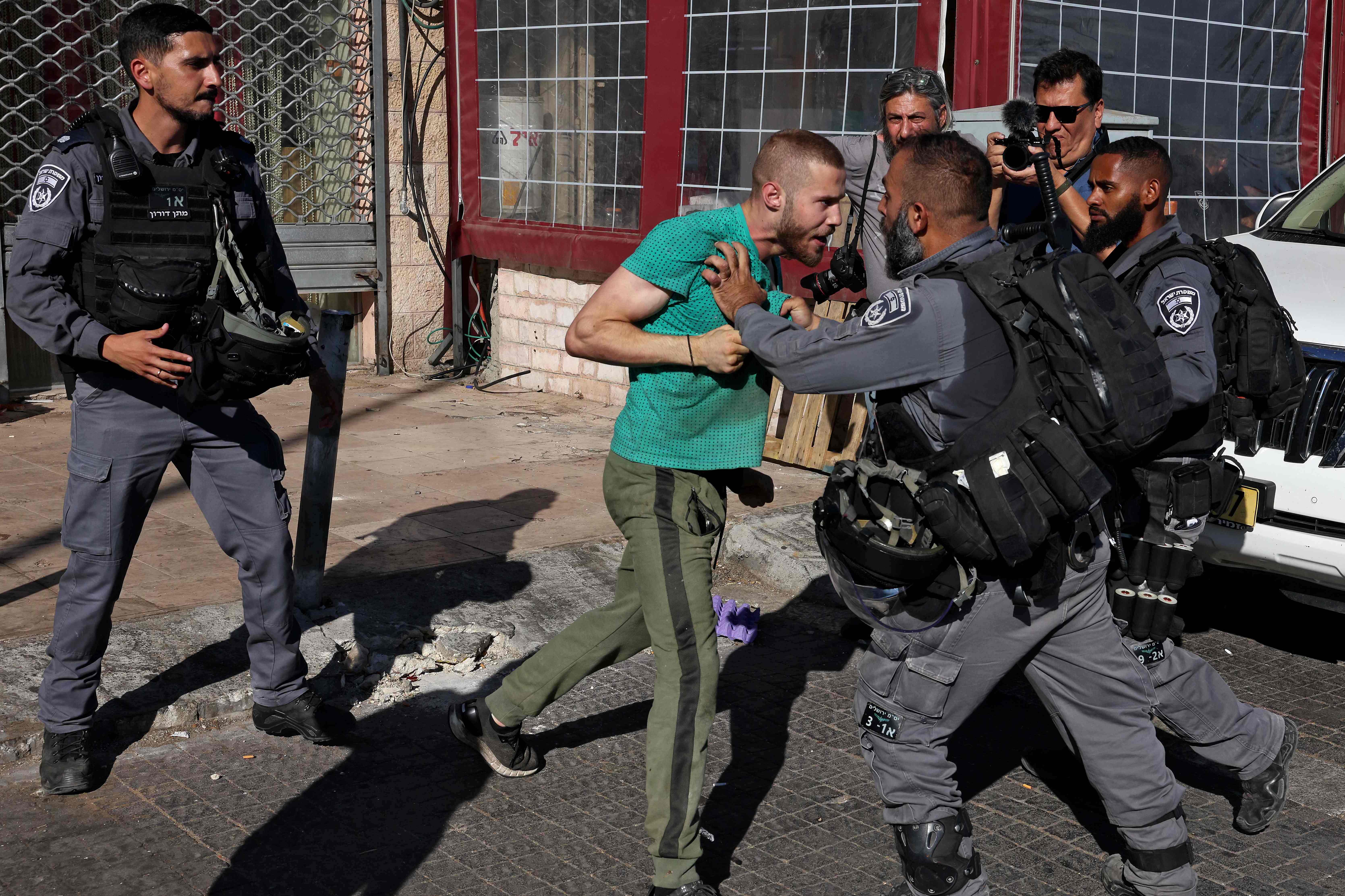Pria Palestina menghadapi anggota pasukan keamanan Israel di Kota Tua Yerusalem, Selasa (15/6), menjelang March of the Flags.