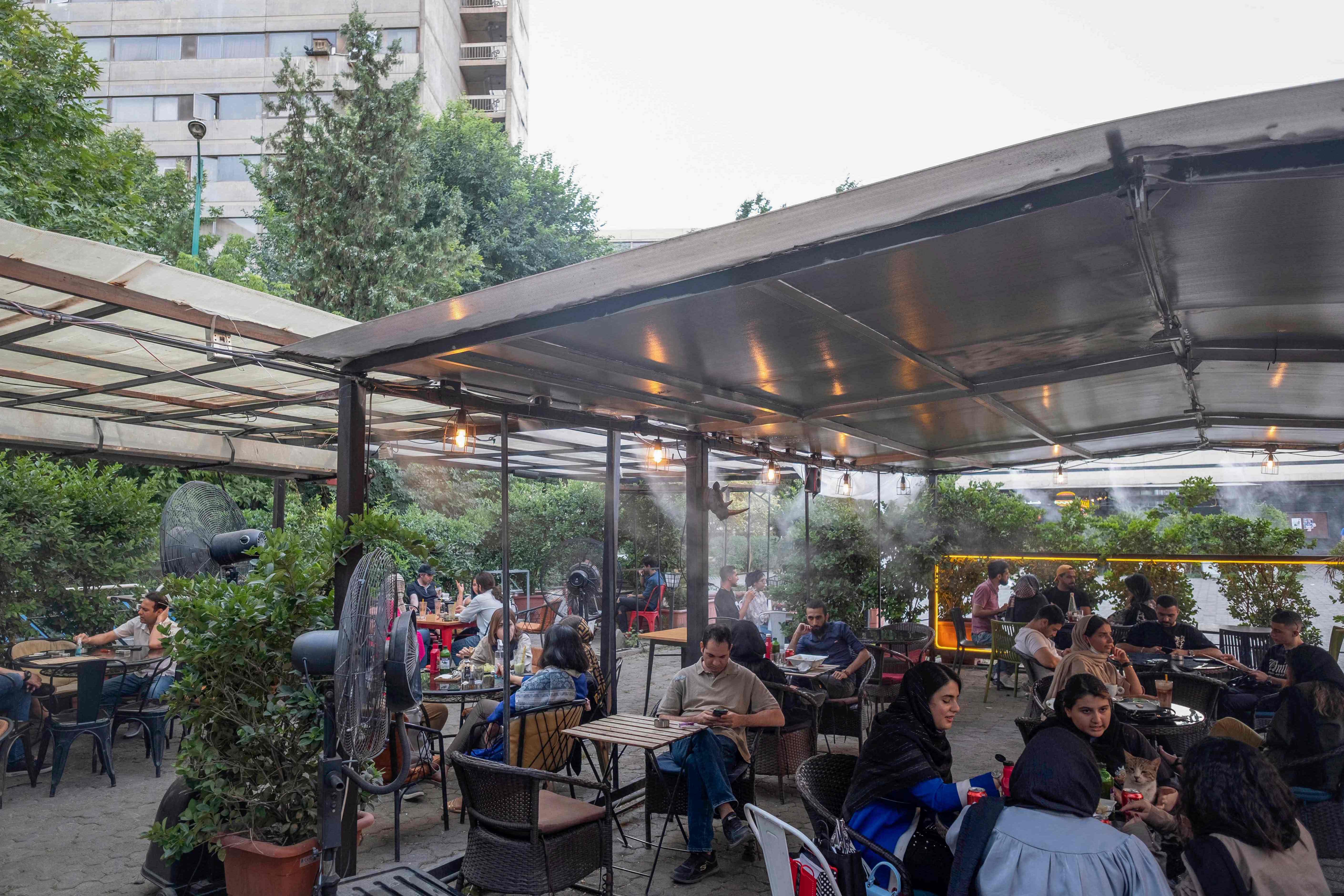 Warga Iran mengobrol di suatu kafe, Ekbatan, Teheran barat pada hari pemilihan Presiden, Jumat (18/6).