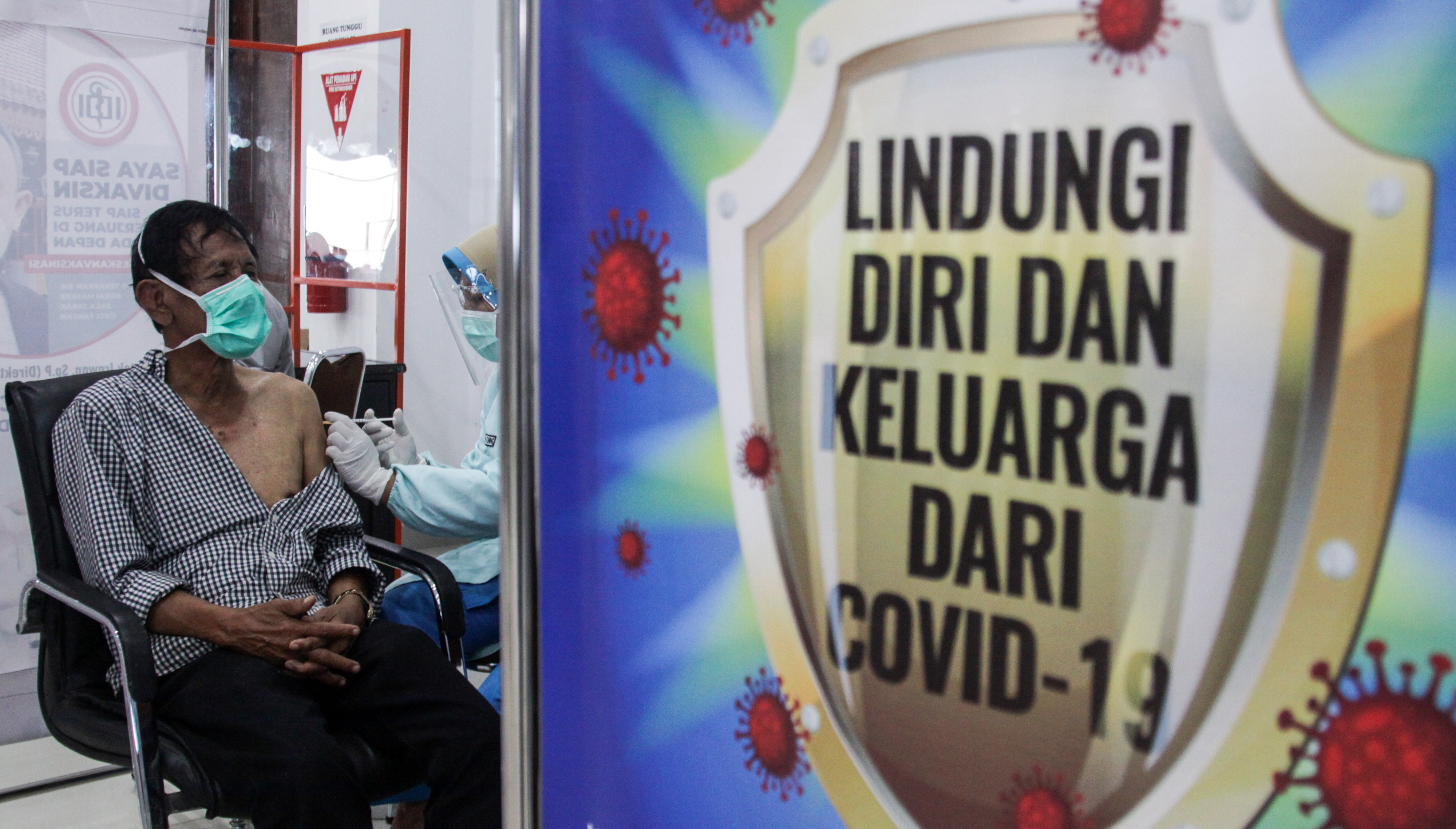 Tenaga medis menyuntikan vaksin Covid-19 kepada lansia.