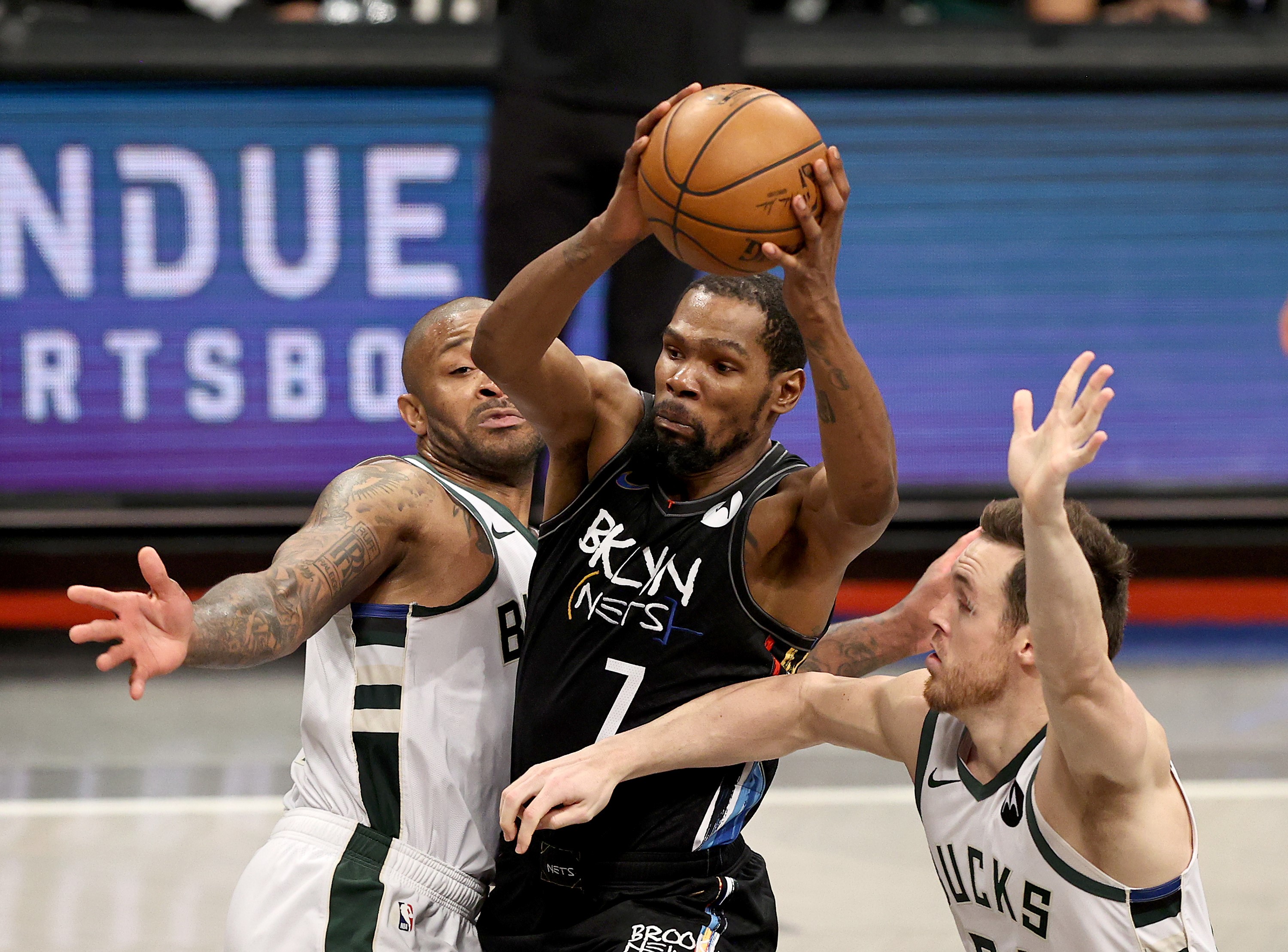 Pemain Brooklyn Nets Kevin Durant berusaha melewati hadangan dua pemain Milwaukee Bucks di Gim 5 playoff NBA.