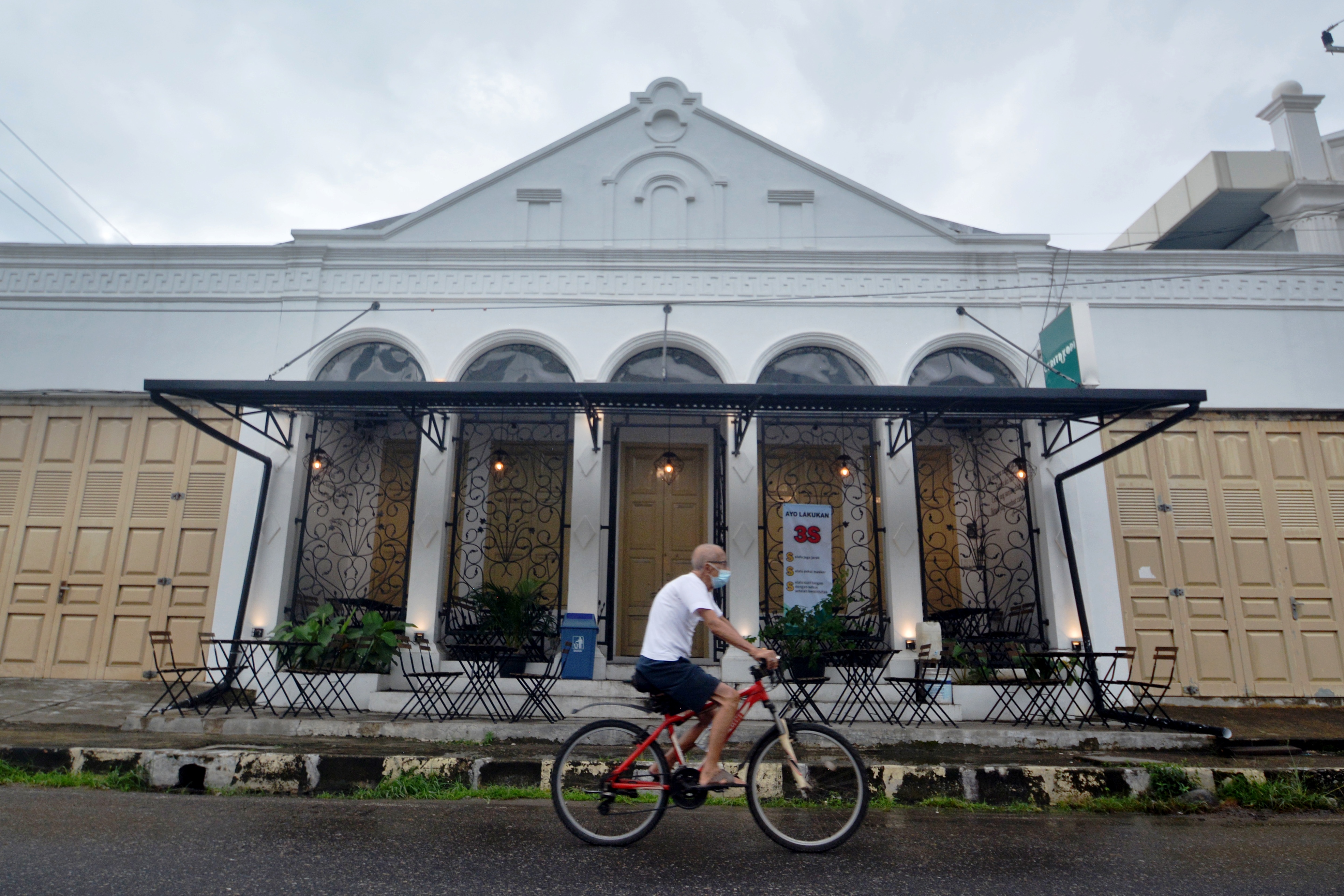 Warga melintasi sebuah kafe kekinian di kawasan Kota Tua Batang Arau, Padang, Sumatera Barat, Jumat (28/5/2021). 