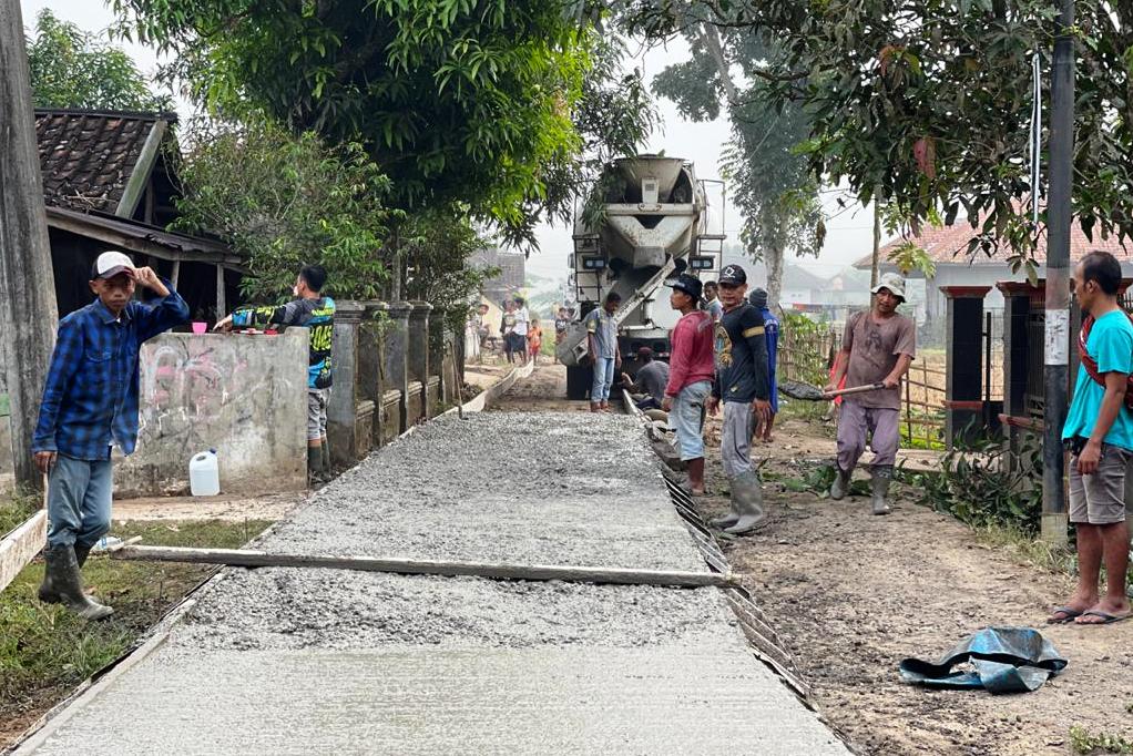 Sejumlah pekerja sedang menyelesaikan pembangunan jalan beton di Desa Bojonglarang, Kecamatan Cijati, Kabupaten Cianjur, Jawa Barat. 