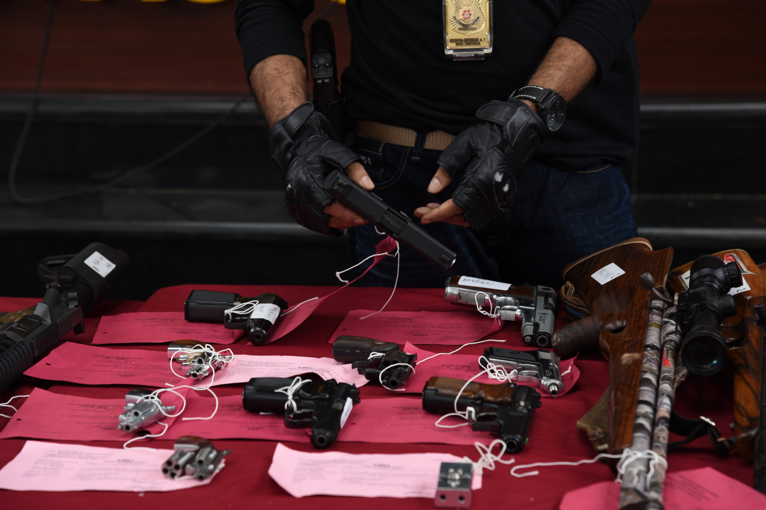 Ilustrasi petugas kepolisian menunjukkan barang bukti senjata api.