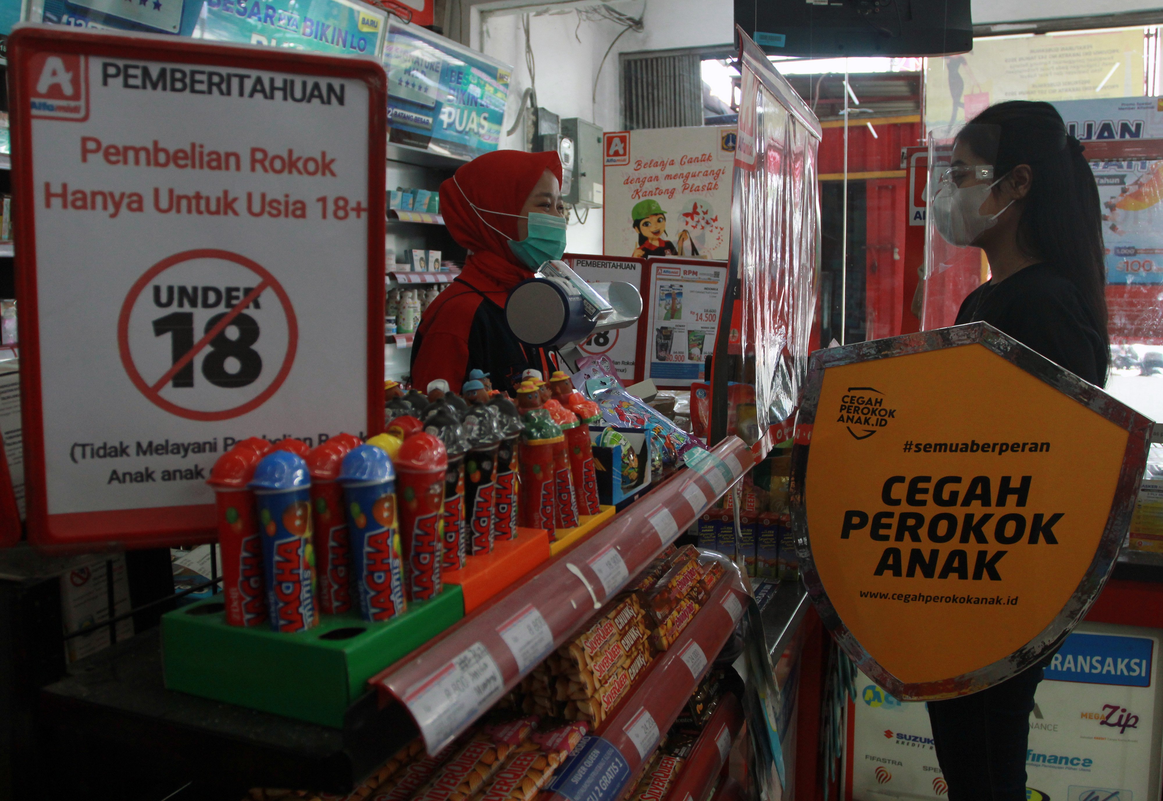 Relawan melakukan edukasi tentang bahaya merokok kepada kasir mini market saat kampanye 