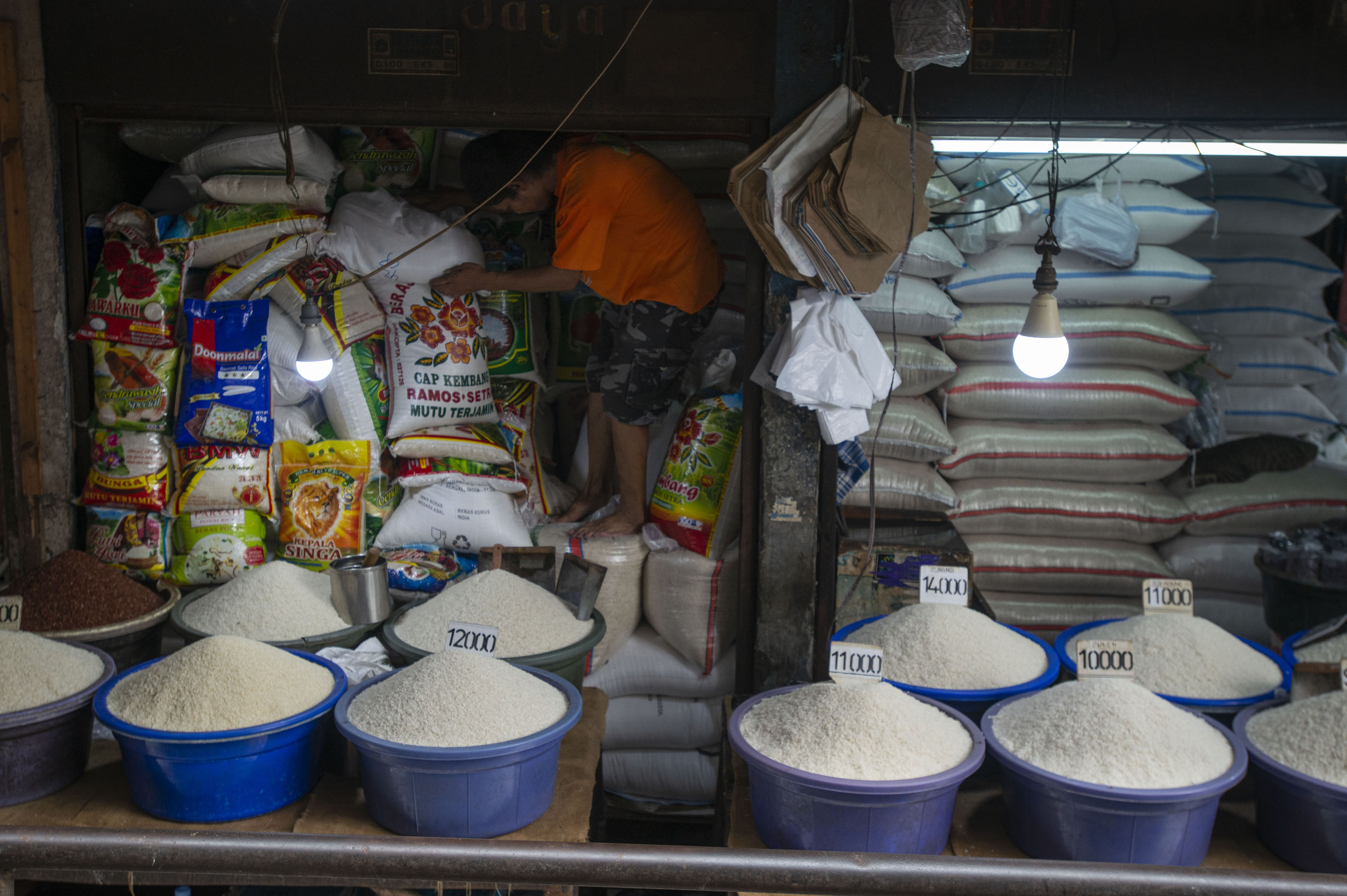 Pedagang menata karung-karung berisi beras yang dijual di Pasar Minggu, Jakarta.