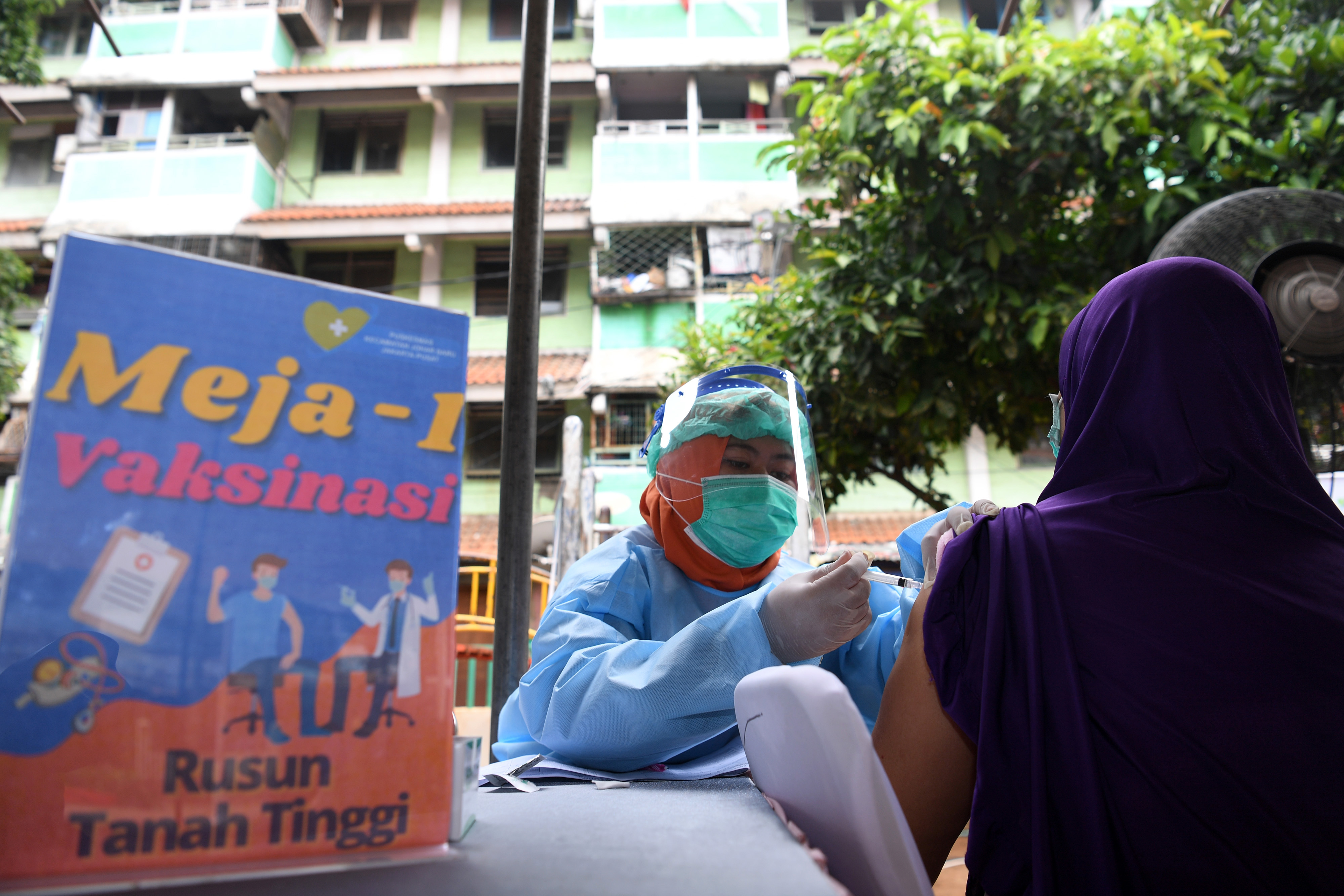 Petugas kesehatan menyuntikkan vaksin covid-19 kepada warga di Rusun Tanah Tinggi, Jakarta.