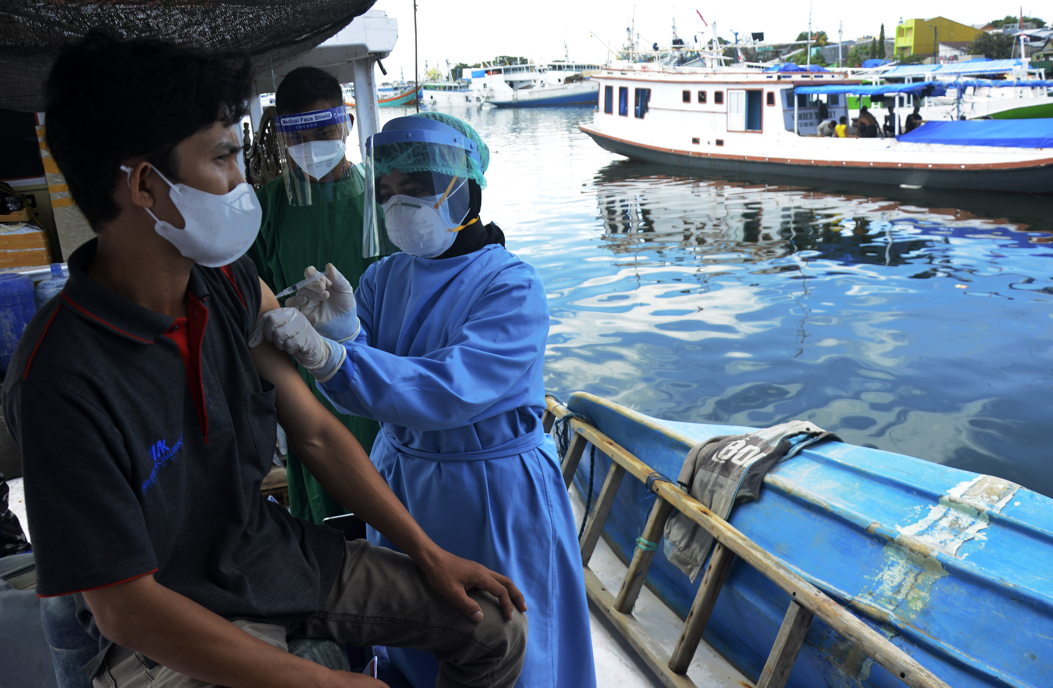Tim medis TNI AL menyuntikkan vaksin covid-19 untuk masyarakat nelayan.