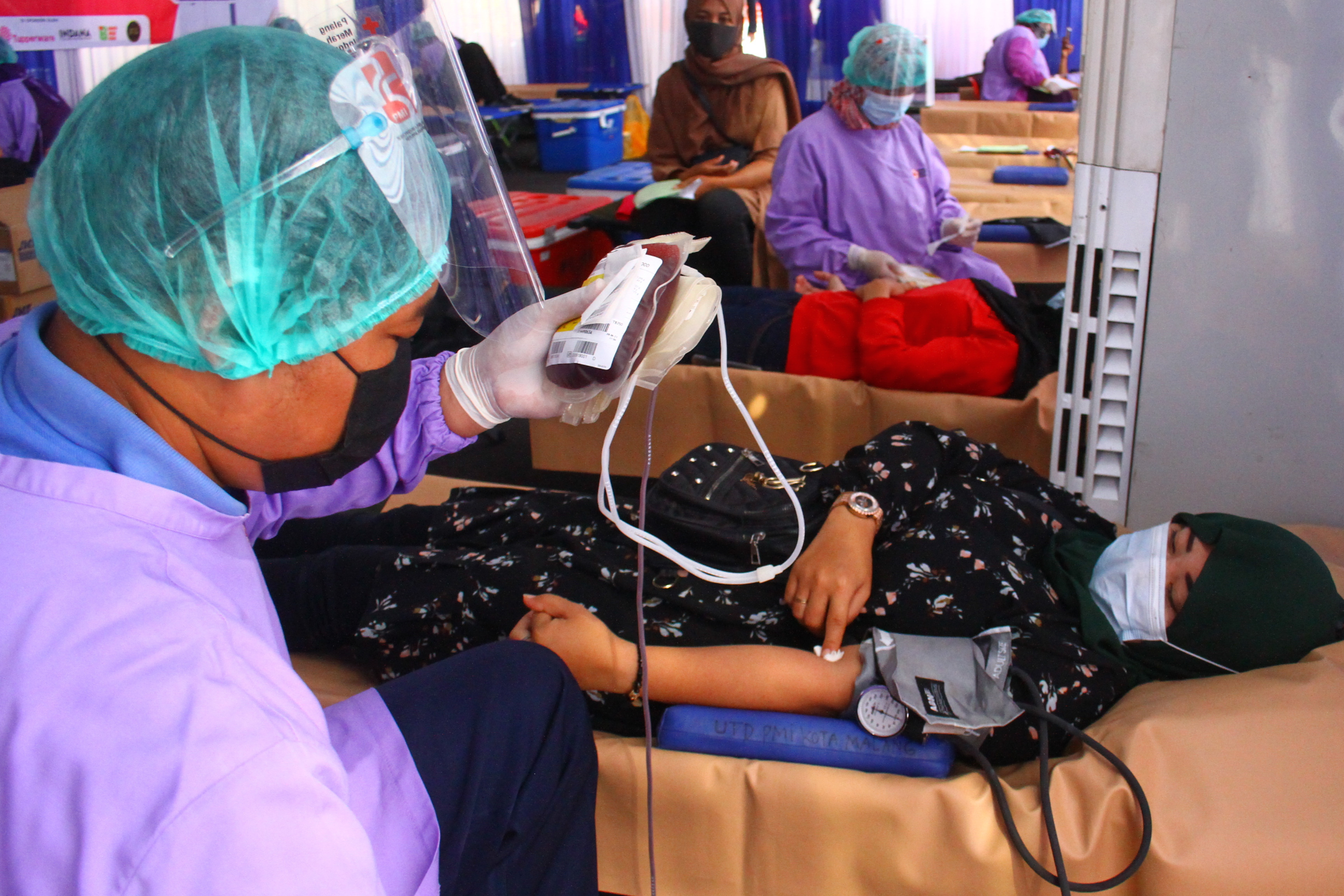 Petugas PMI mengambil darah pendonor dalam kegiatan donor darah di depan Balai Kota Malang, Jawa Timur, Sabtu (12/6/2021)
