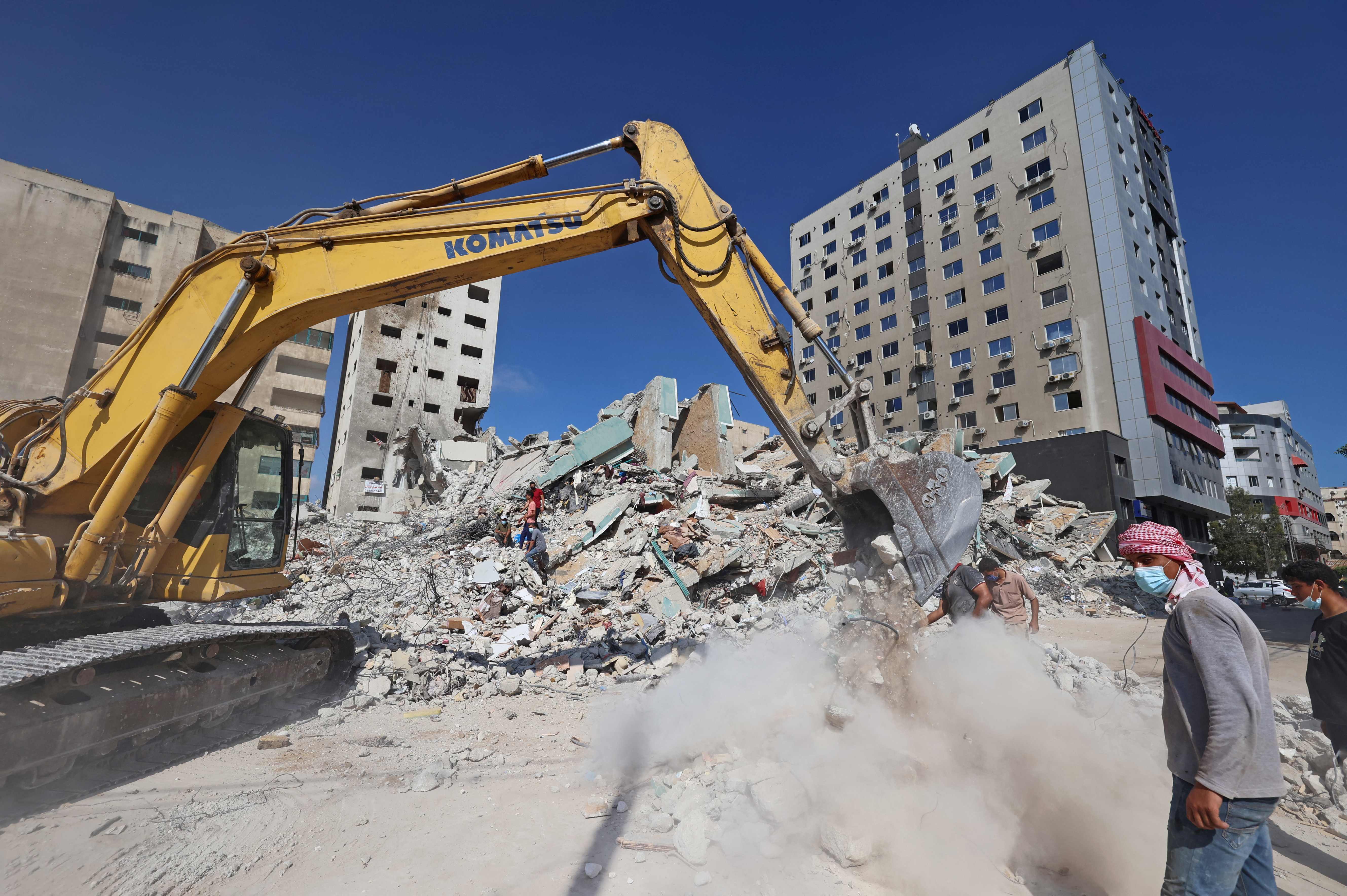 Para pekerja Palestina tengah meratakan gedung di Jalur Gaza yang hancur dibombardir Israel pada Selasa (22/6). 