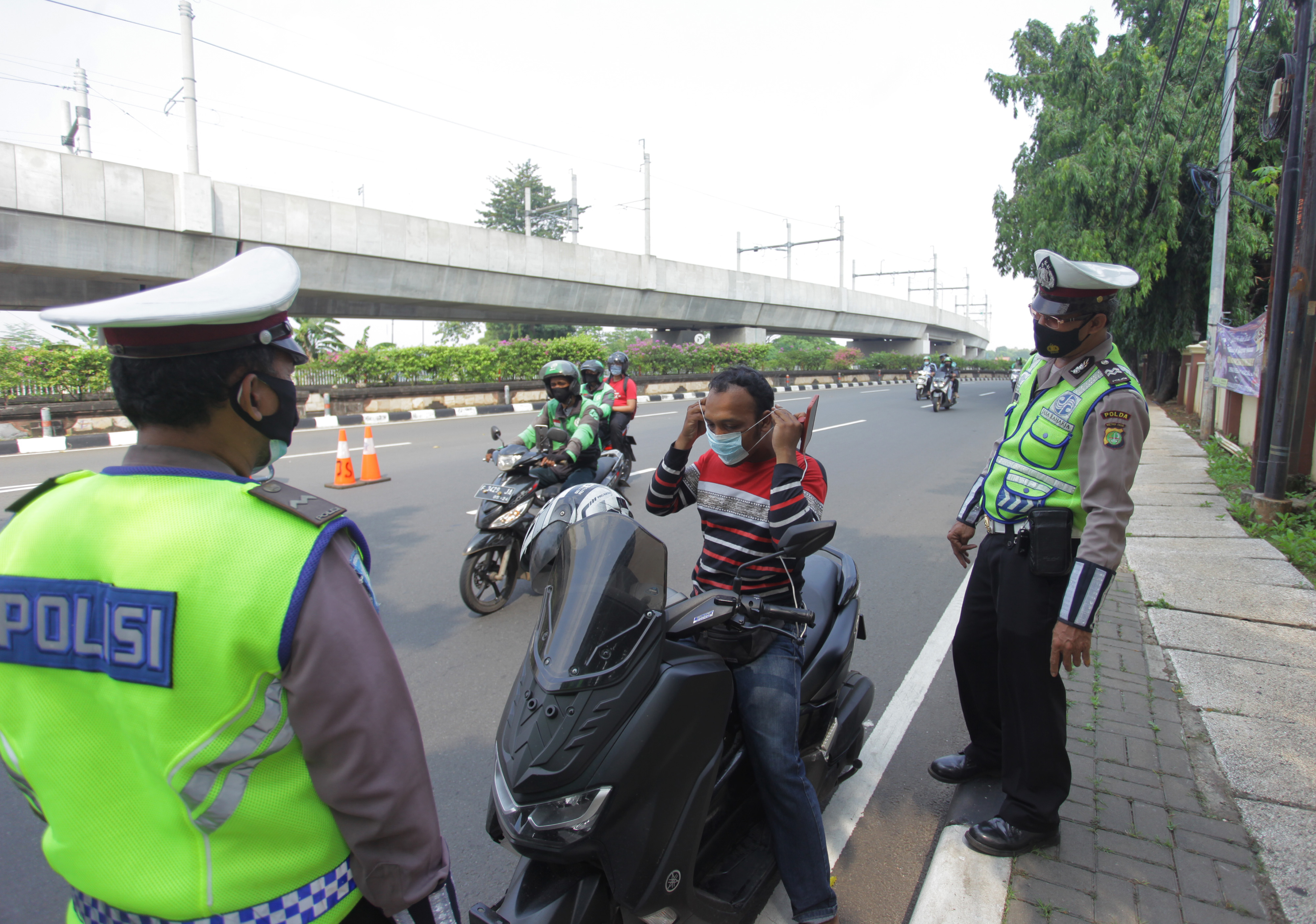 Petugas gabungan melakukan pengecekan kendaraan saat penyekatan larangan mudik lebaran 2021 di sekitar Pasar Jumat, Lebak Bulus, Jakarta.