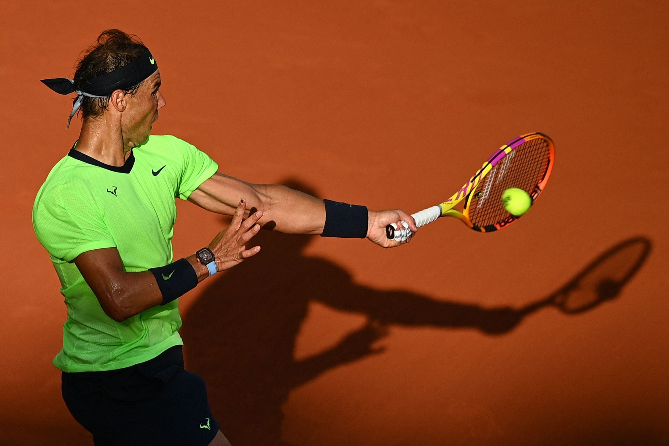 Petenis Spanyol Rafael Nadal berusaha mengembalikan bola ke arah lawannya, Jannik Sinner, dari Italia.