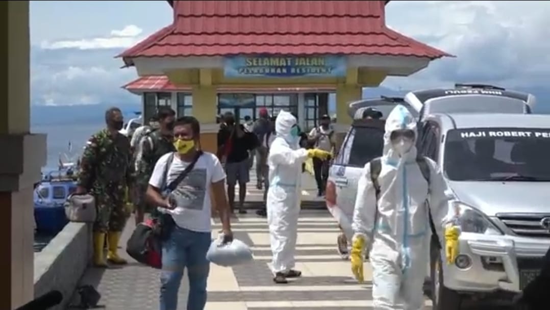 Kariyawan PT NHM dibawa dari Halut ke Ternate melalui Pelabuhan Resident dengan dikawal petugas kesehatan.