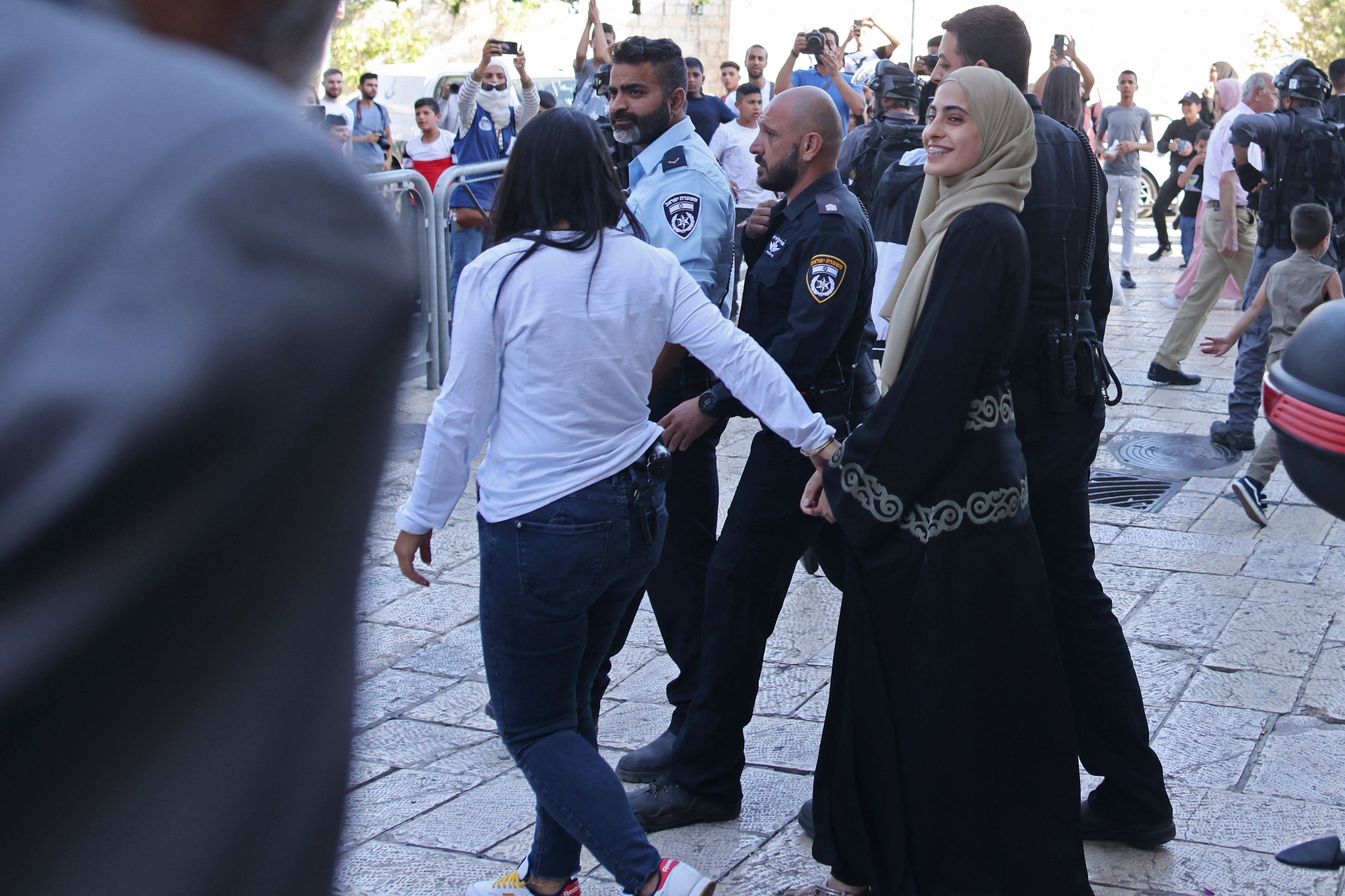 Petugas keamanan Israel memindahkan aktivis Palestina, Mona el-Kurd, 23, Minggu (6/6), dari kantor polisi di Jerusalem timur.