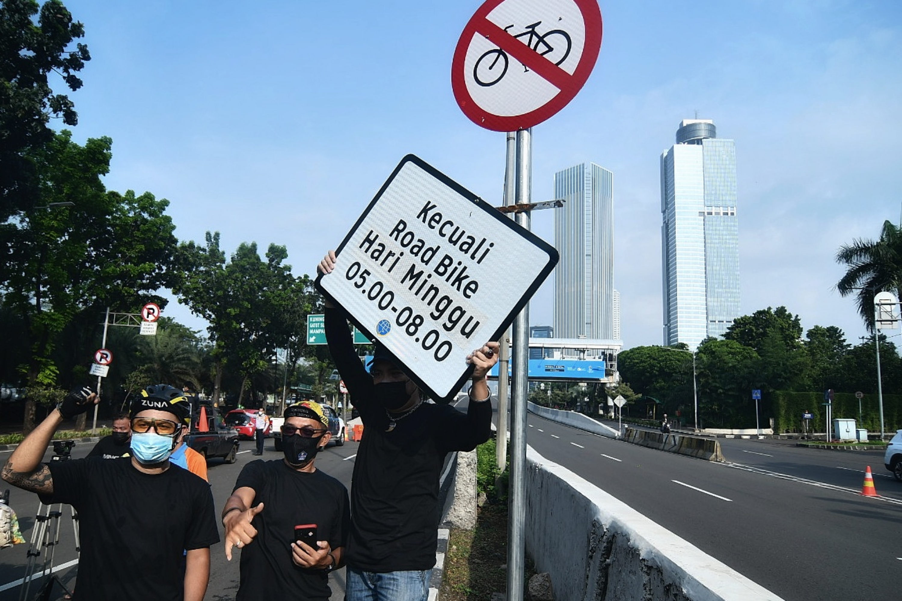 Sejumlah pesepeda menyaksikan pencopotan rambu khusus road bike