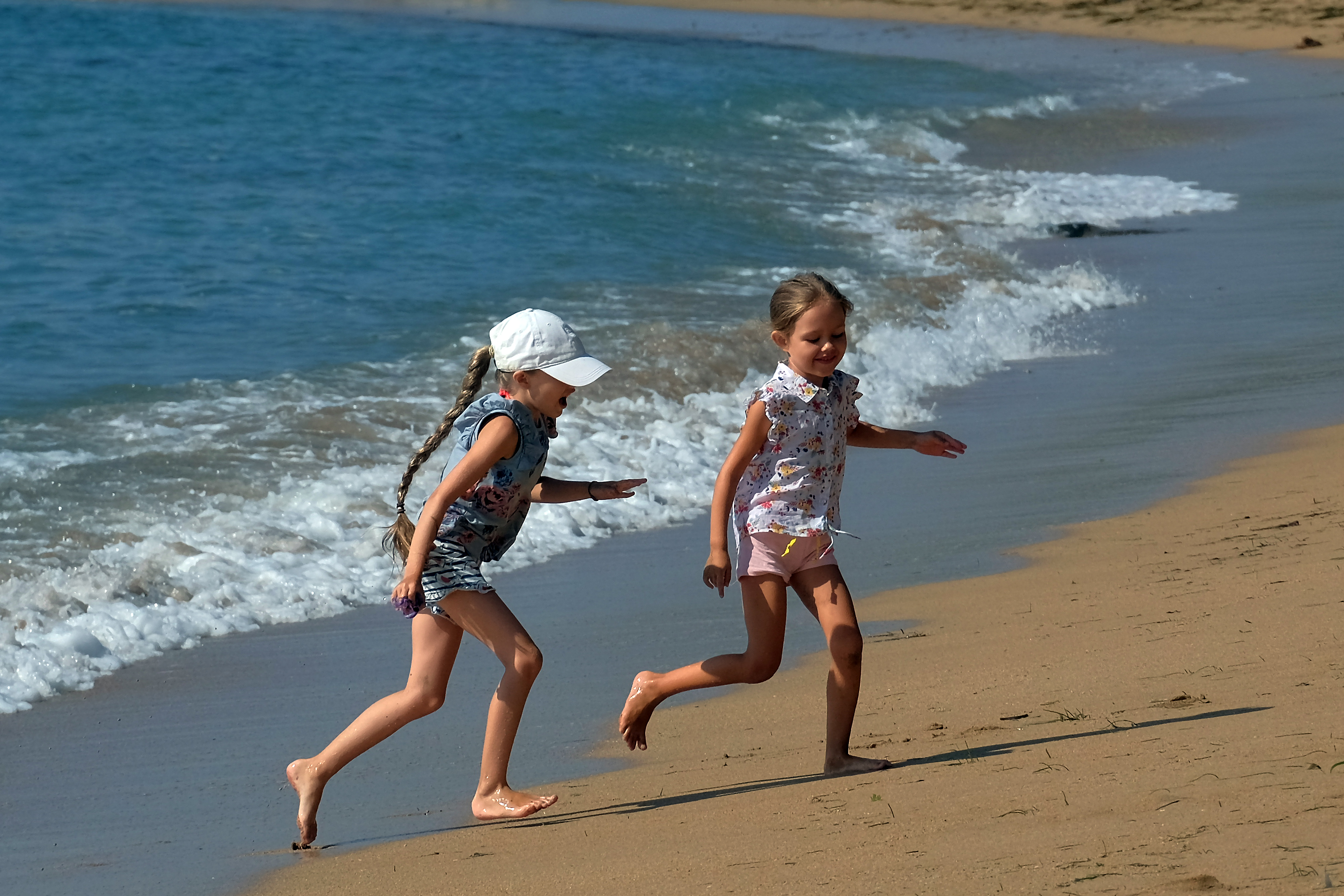 Dua anak turis asing menikmati suasana Pantai Sindhu, Sanur, Bali.