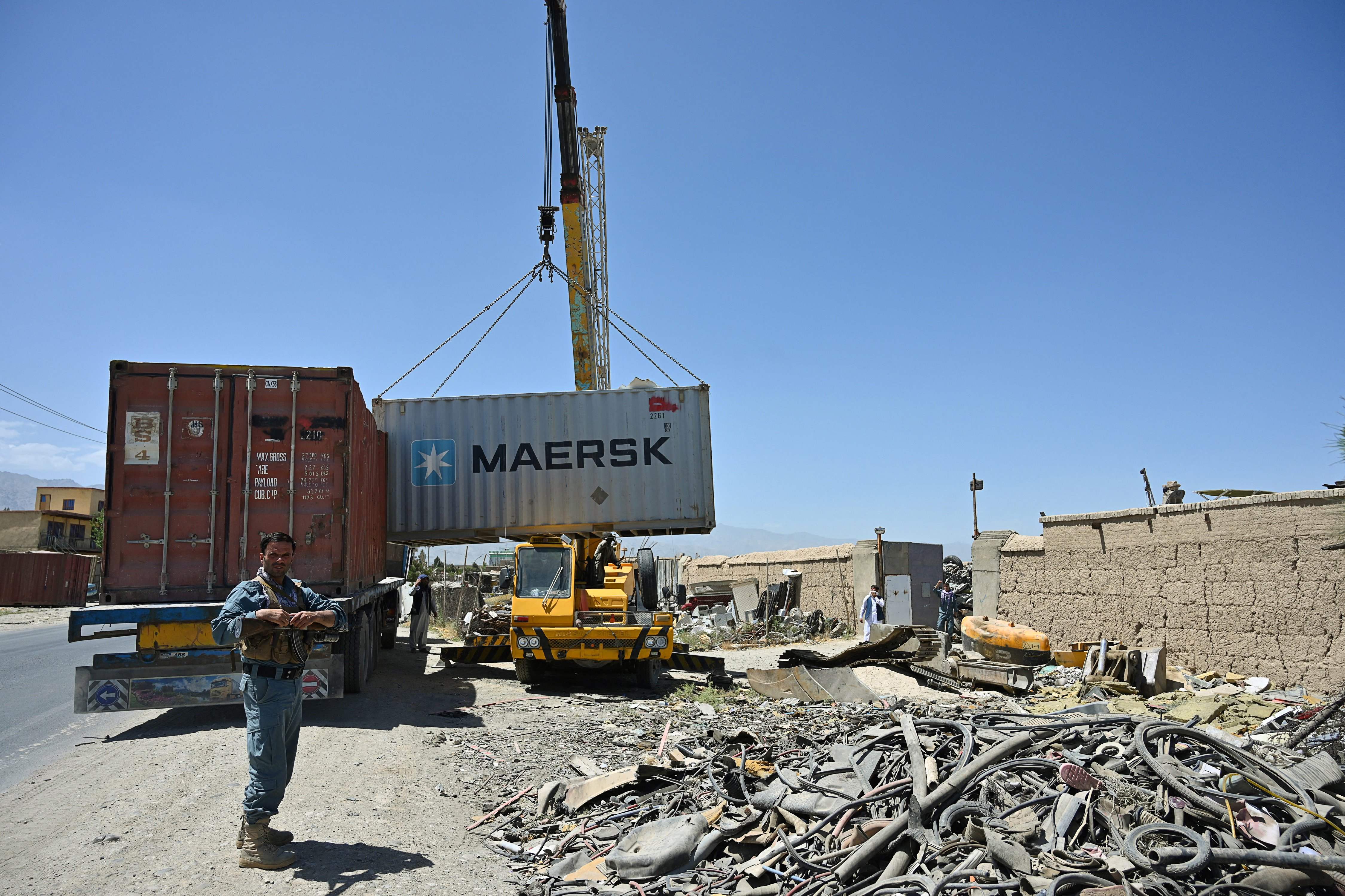 Polisi Afghanistan berjaga saat kendaraan kontainer yang memuat barang-barang milik tentara AS dari Pangkalan Udara Bagram, Afghanistan.