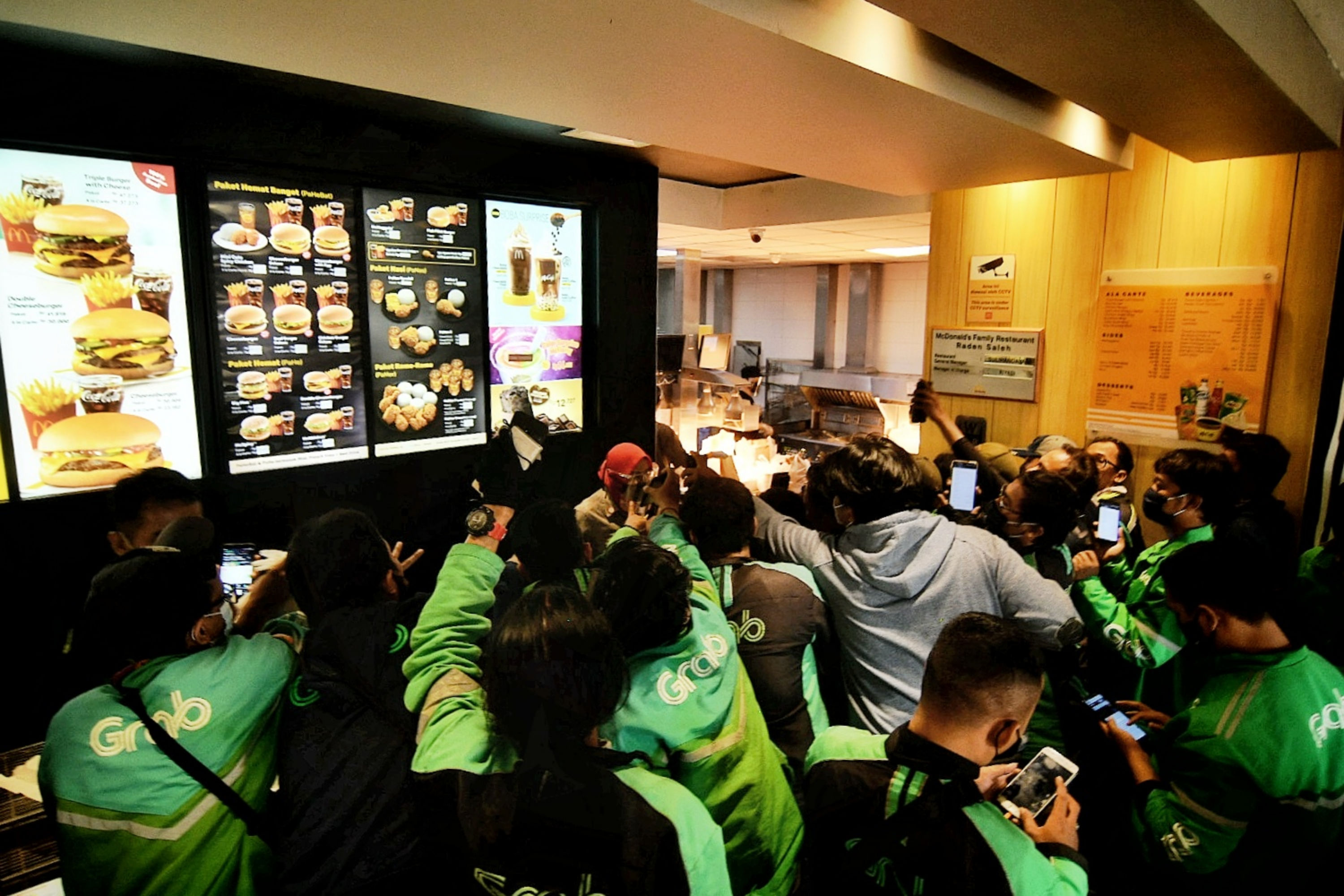 Pengemudi ojol mengantre untuk mengambil pesanan BTS Meal di gerai McDonald's Raden Saleh, Jakarta, Rabu (9/6).