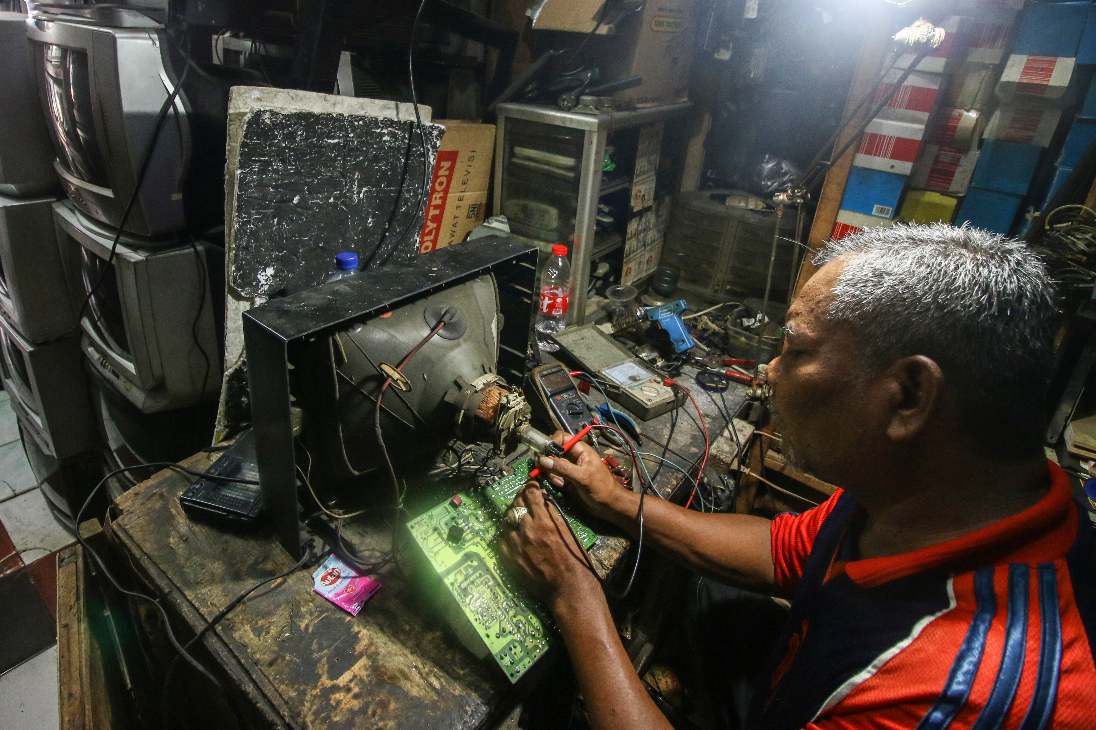 Pekerja memperbaiki TV di Kebayoran, Jakarta, beberapa waktu lalu.