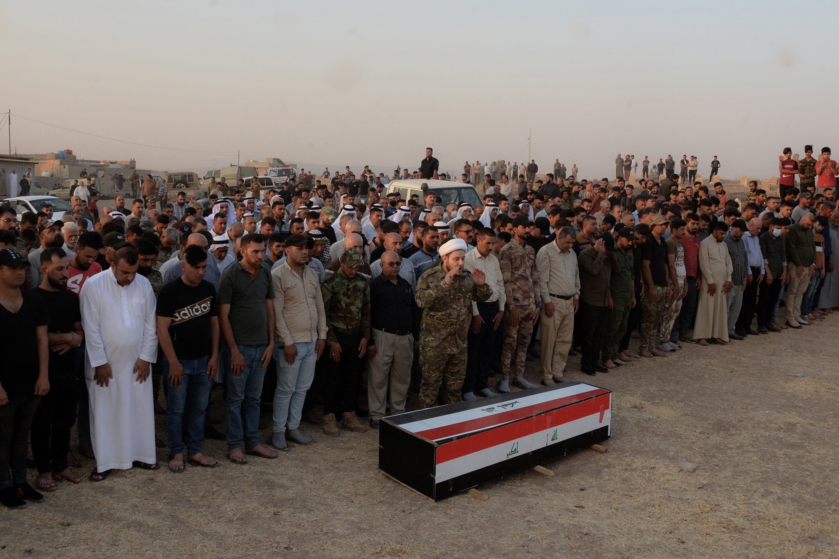 Para pelayat Irak menghadiri pemakaman seorang pejuang aliansi paramiliter Hashed al-Shaabi yang tewas akibat serangan udara AS.