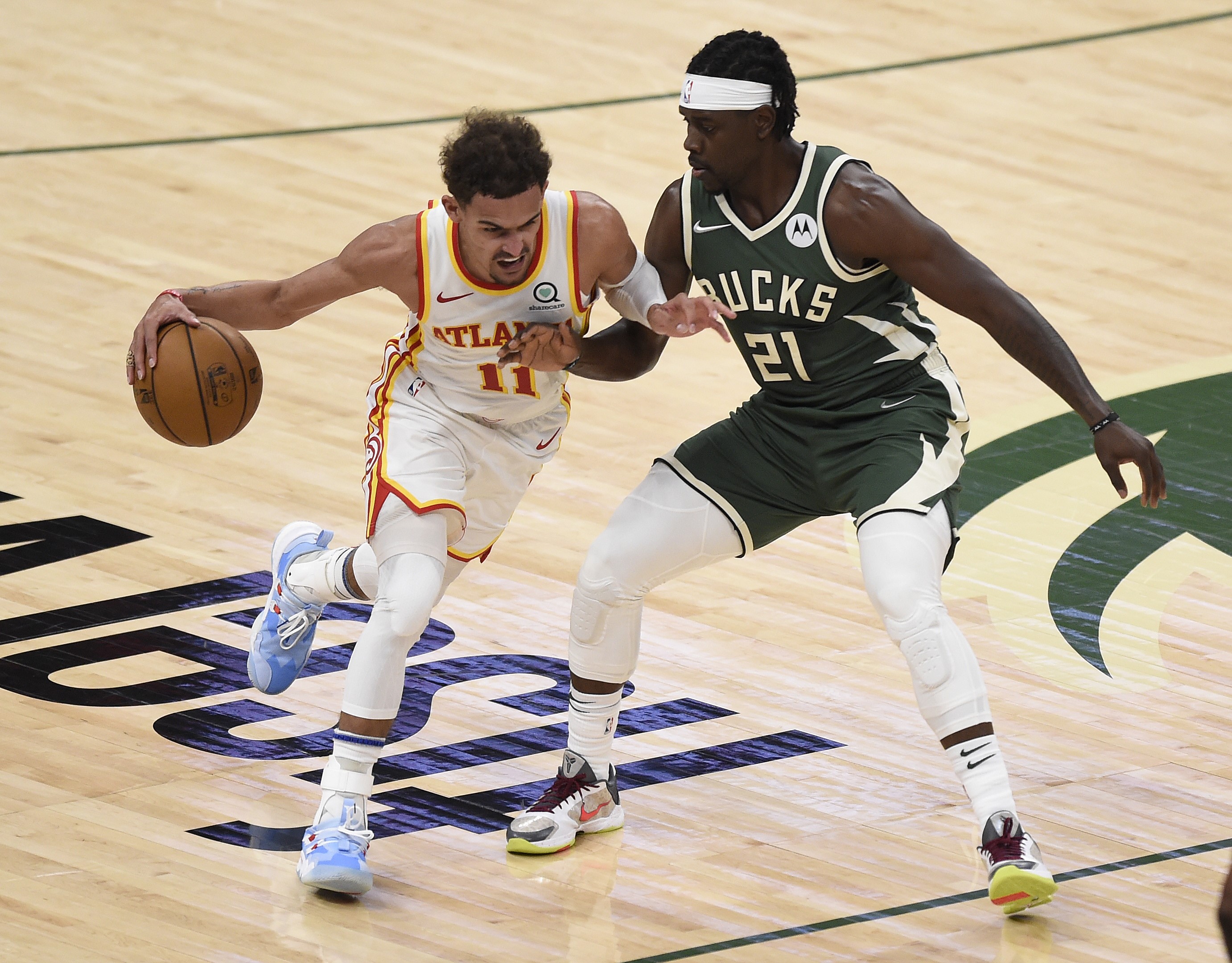 Pemain Atlanta Hawks Trae Young (kiri) berusaha melewati hadangan pemain Milwaukee Buck Jrue Holiday di laga final Wilayah Timur playoff NBA