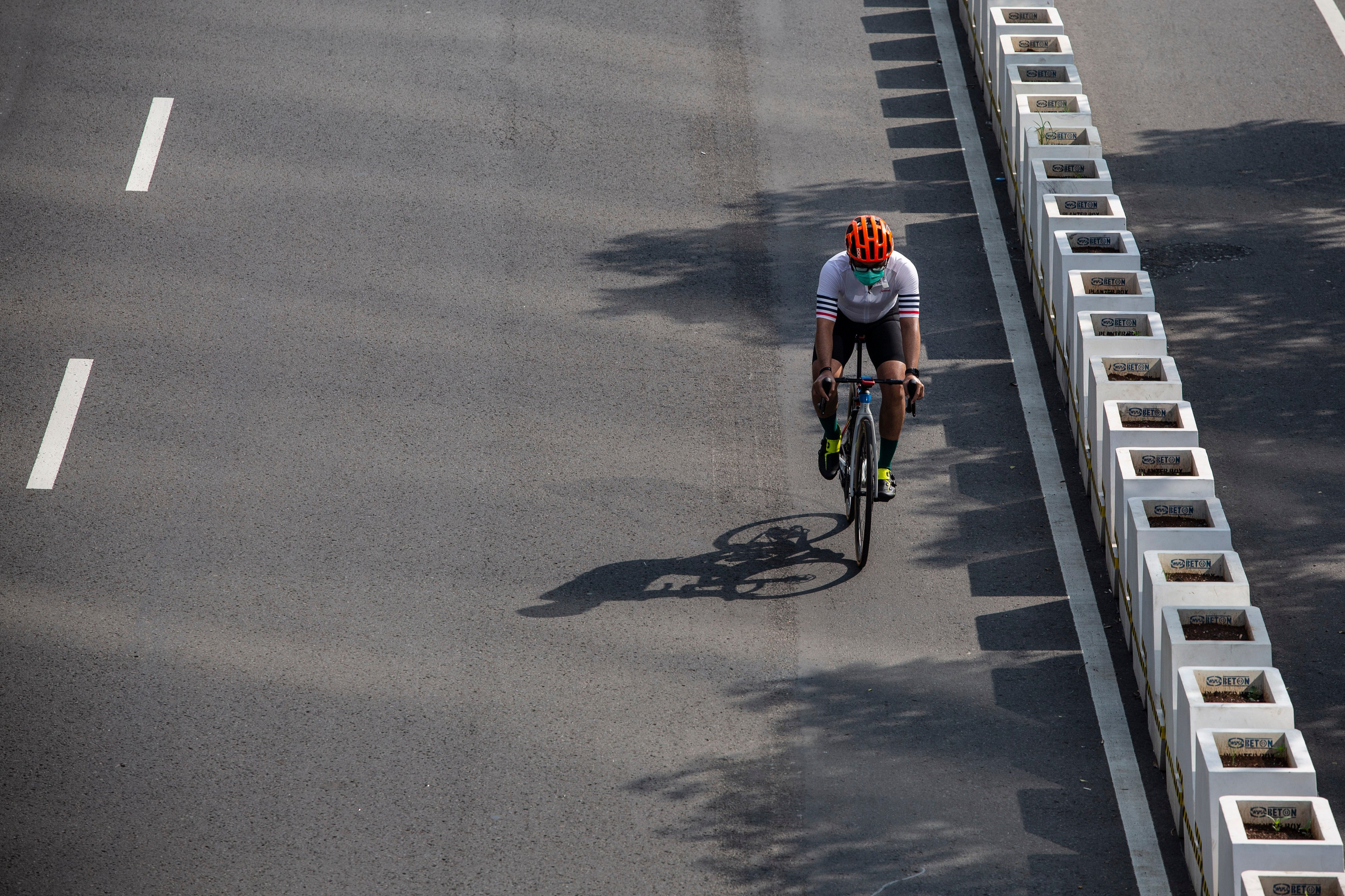 Pesepeda memacu kecepatan saat melintas di Jalan Jenderal Sudirman, Jakarta.
