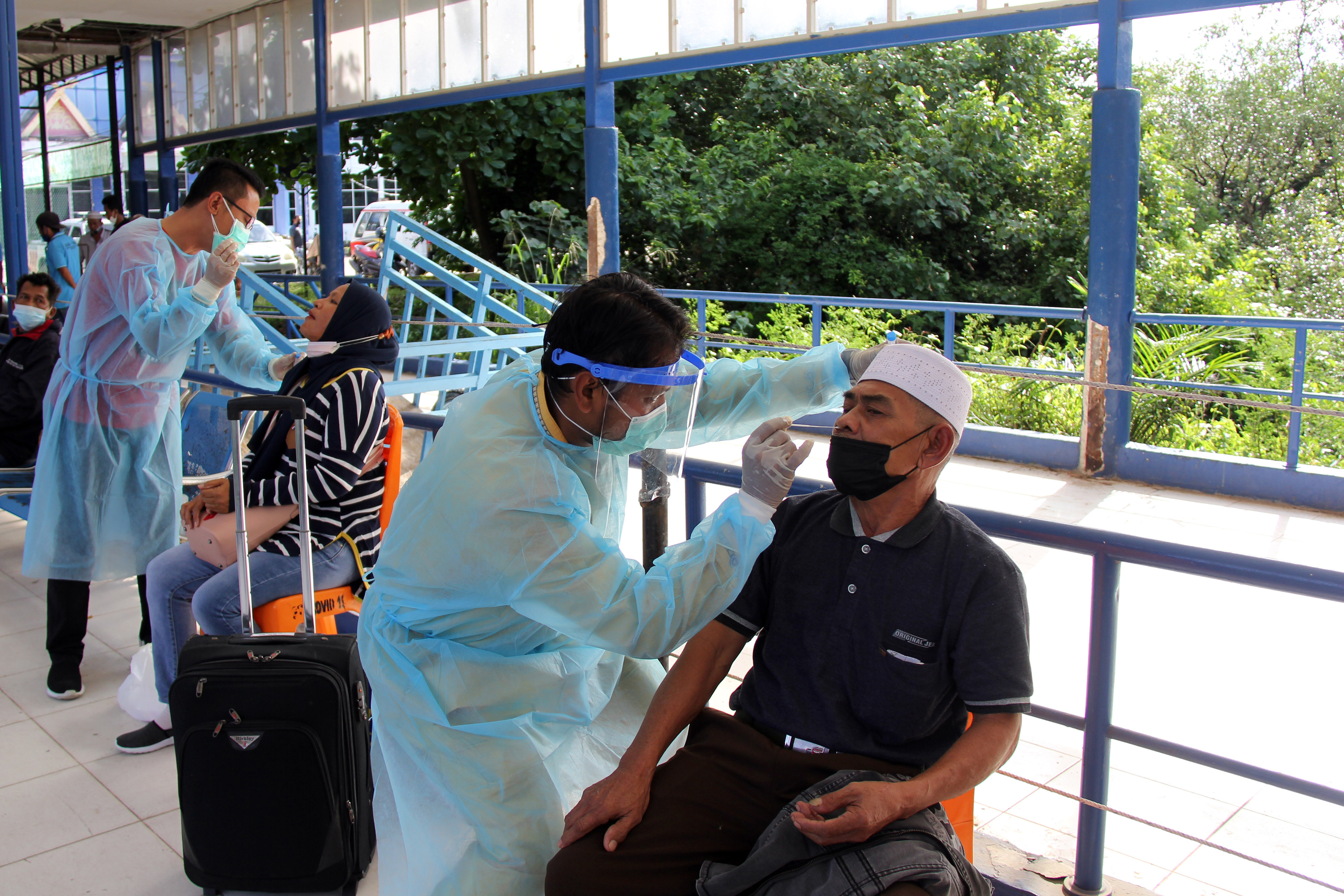 Petugas melayani tes Rapid Antigan gratis bagi penumpang kapal dari Pulau Batam di Pelabuhan Bandar Sri Junjungan Dumai, Riau.