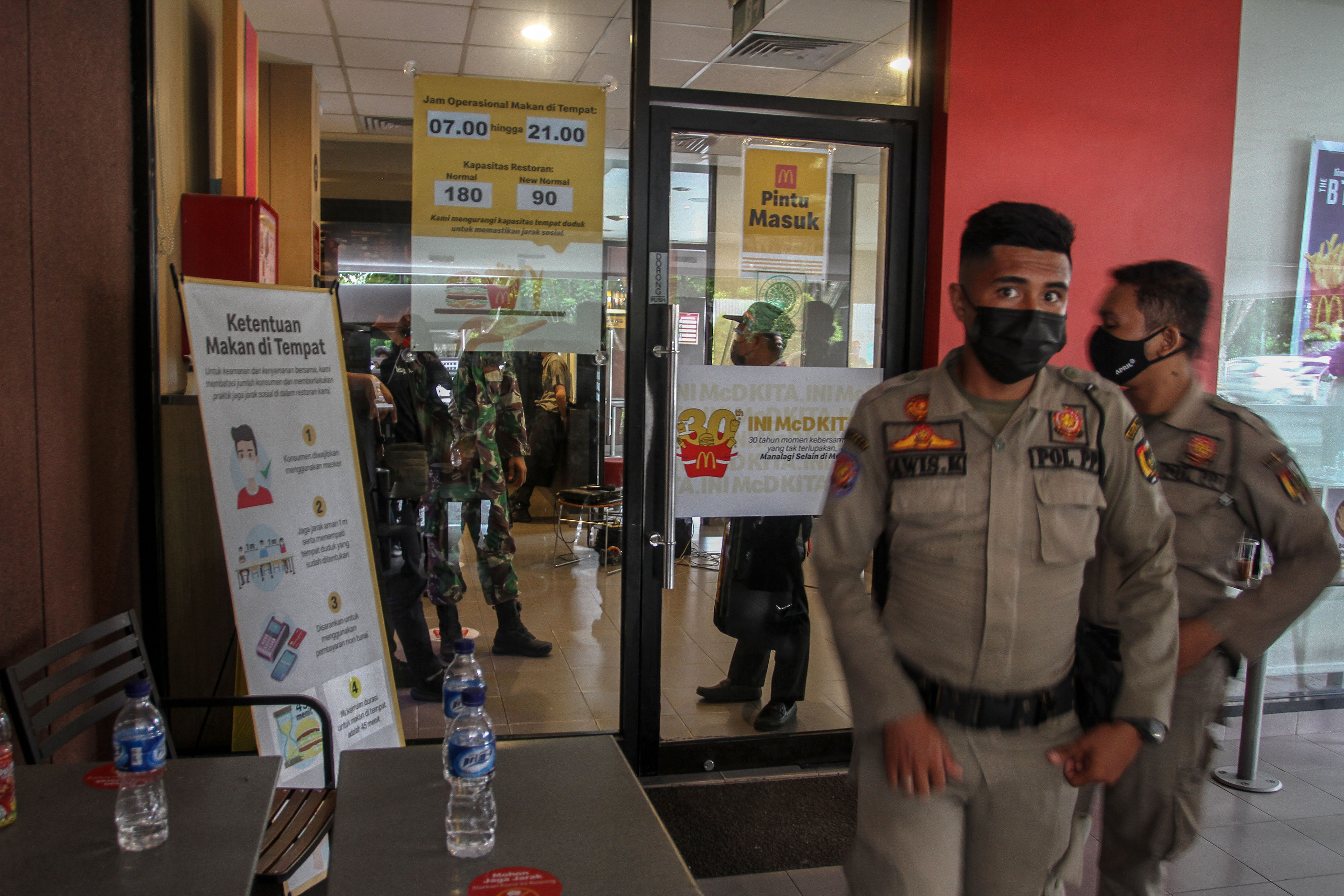 Petugas Satpol PP berjaga di gerai McDonald's
