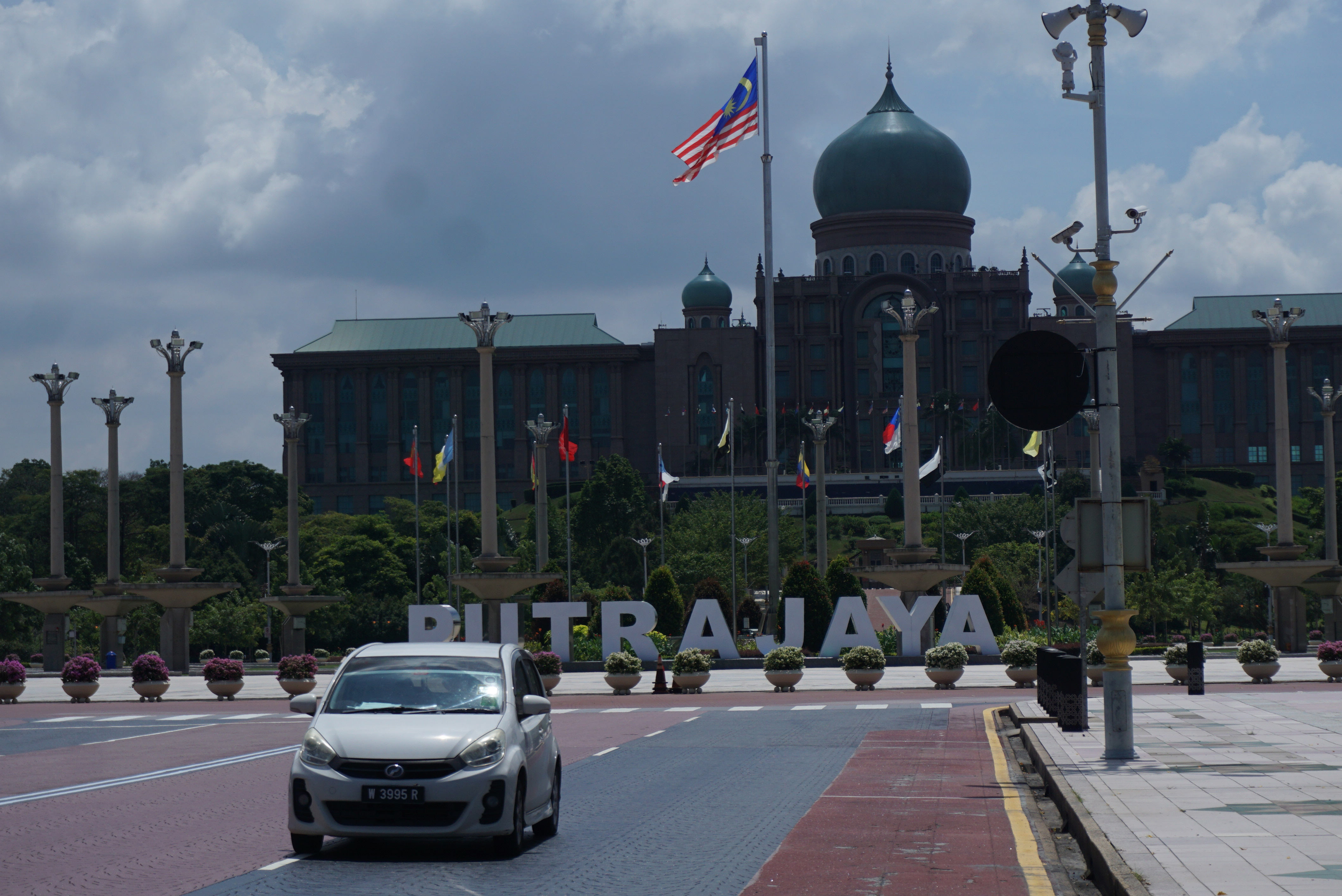 Mobil melintas dengan latar belakang Kantor Perdana Menteri Malaysia, di Putrajaya, Malaysia