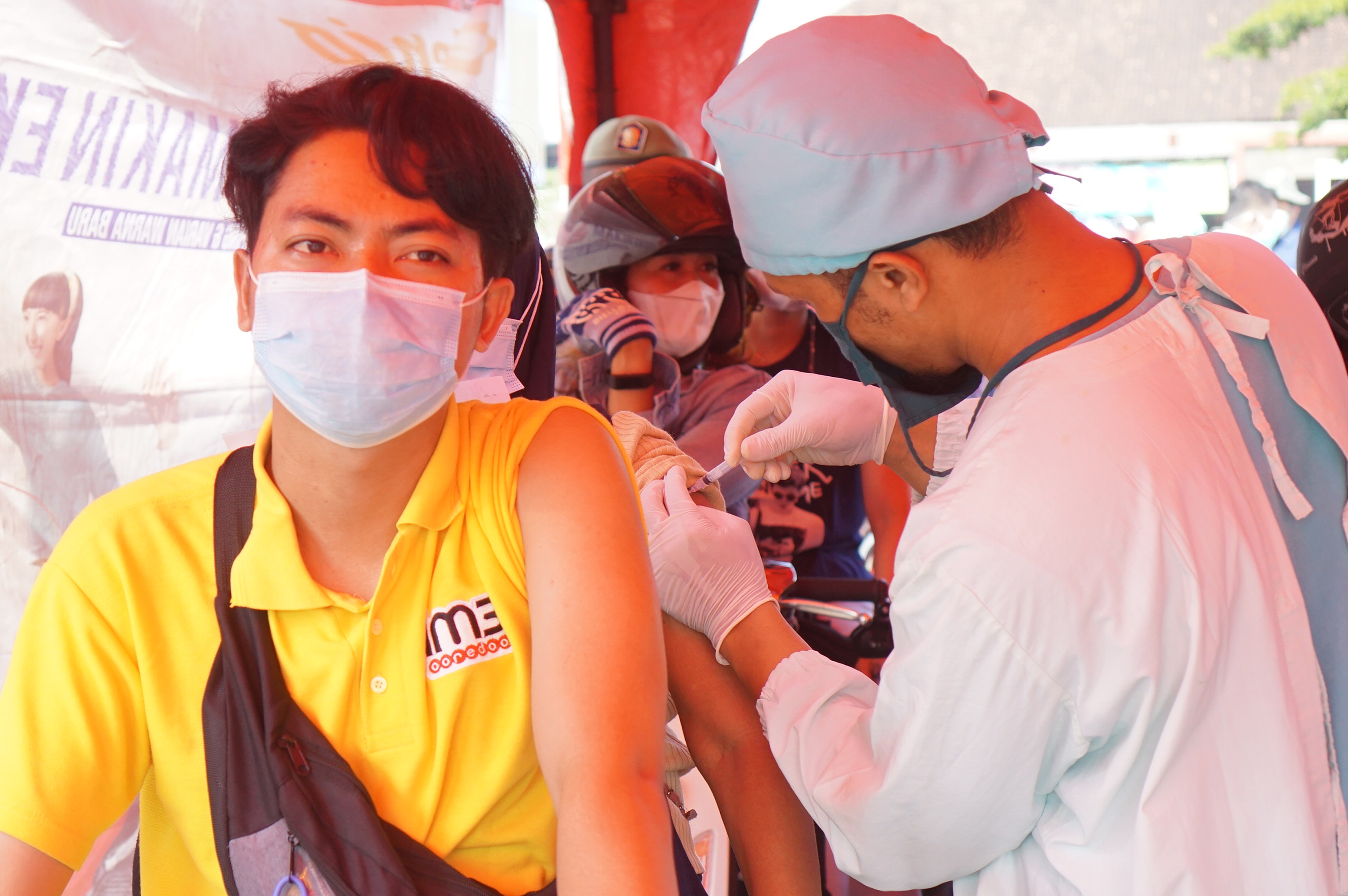 Petugas menginjeksikan vaksin covid-19 ke pengendara motor dalam program vaksinasi lantatur (layanan tanpa turun) di Tulungagung, Jawa Timur