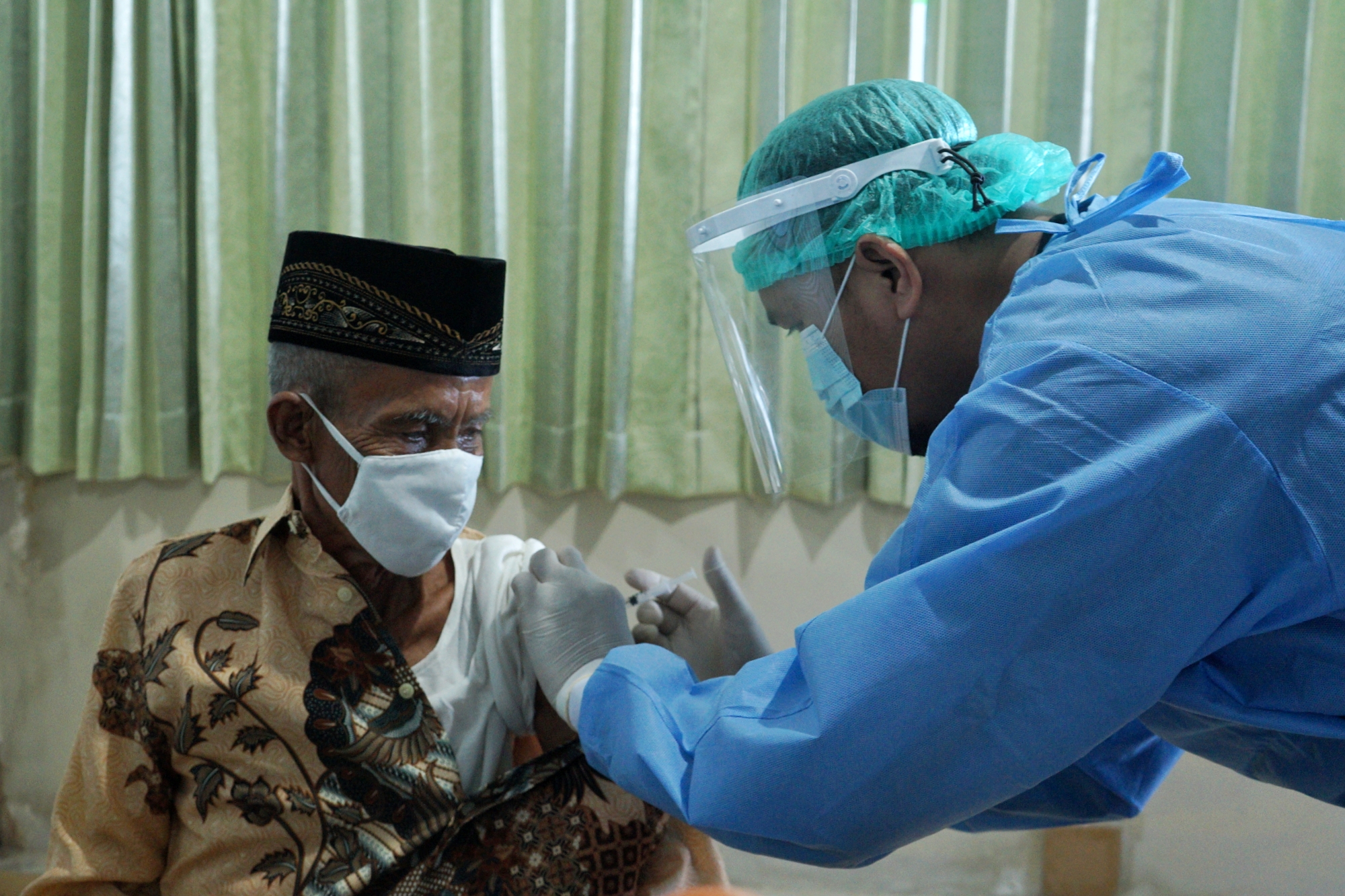 Vaksinator menyuntikan vaksin Covid-19 kepada warga lansia di Dinkes Daerah Istimewa Yogyakarta, Kamis (22/4/2021).