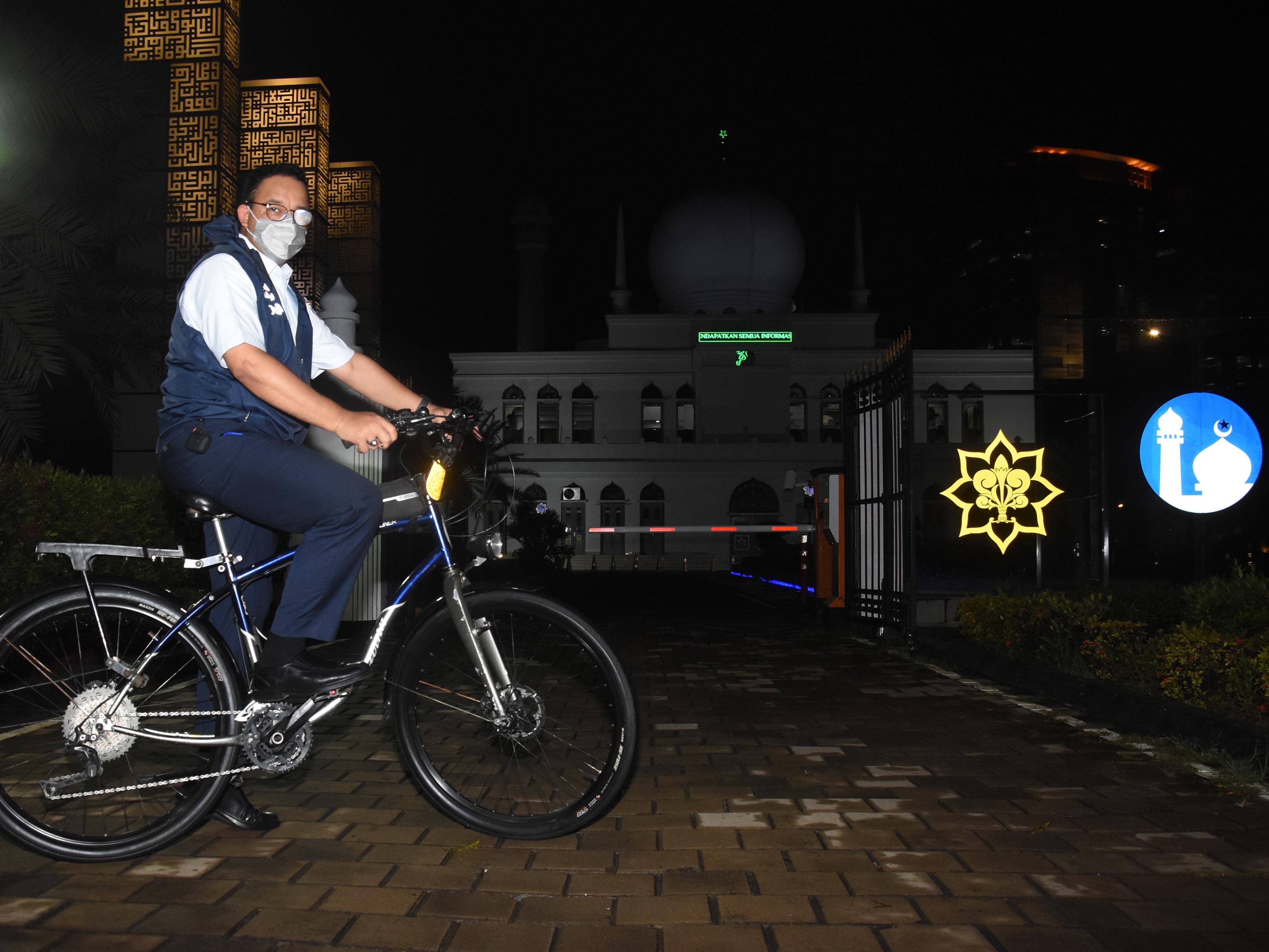 Gubernur DKI Jakarta Anies Baswedan memasuki Masjid Al-Azhar untuk beribadah di sela bersepeda usai pulang kantor di Jalan Sisingamangaraja.