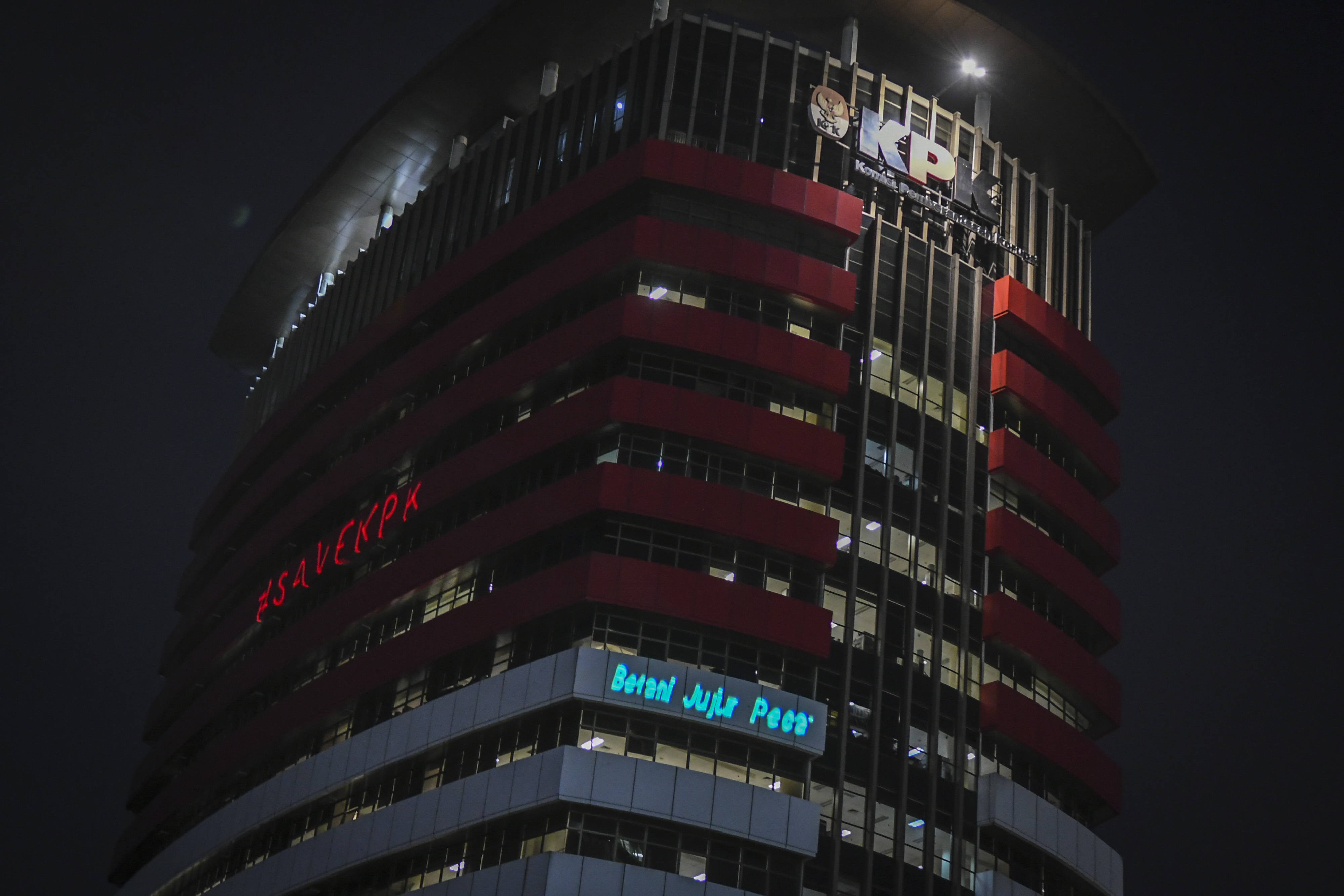 Aktivis Greenpeace menembakan sinar laser yang bertuliskan #saveKPK saat menggelar aksi di Gedung Merah Putih KPK, Jakarta, Senin (28/6).