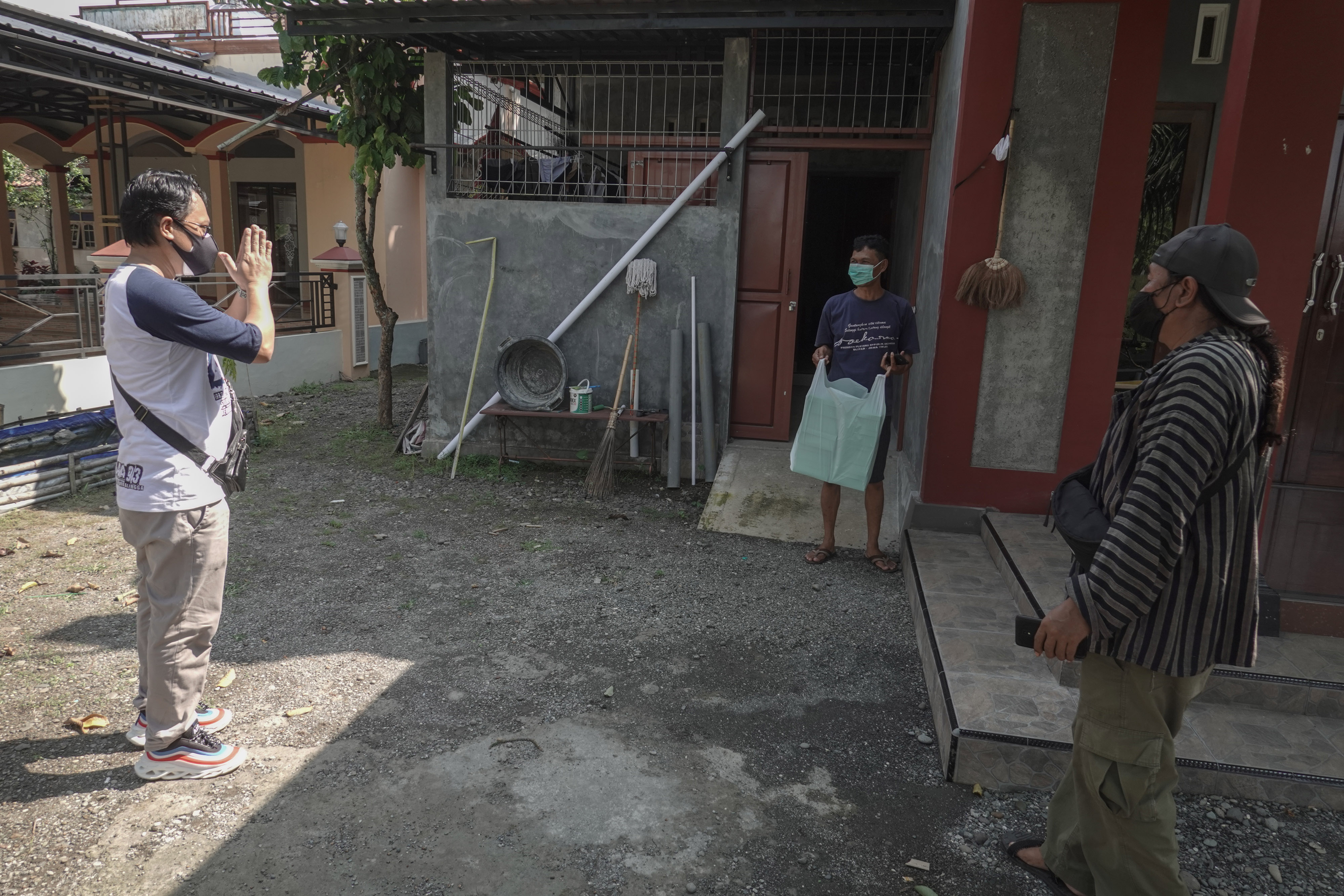 Relawan menyerahkan bantuan makanan kepada perwakilan warga untuk pasien covid-19 di Desa Grecol, Kalimanah, Purbalingga, Jawa Tengah.