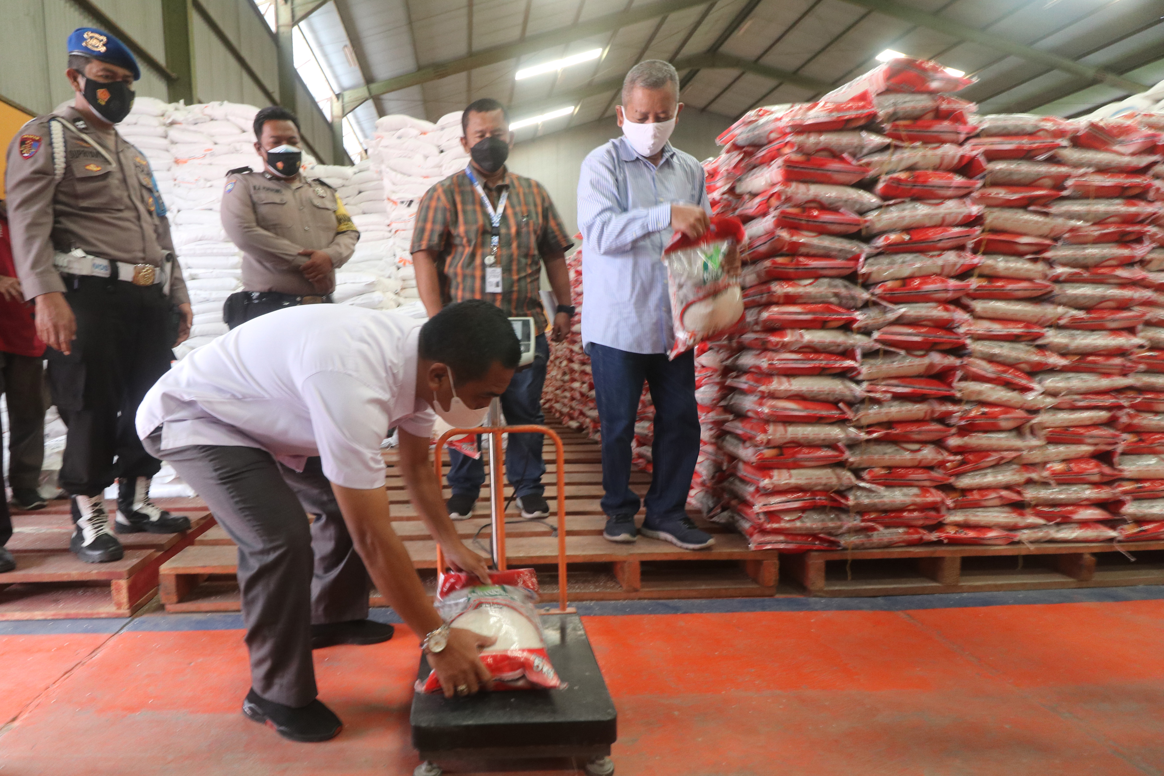 Petugas melakukan pengecekan berat beras bantuan Pemberlakuan Pembatasan Kegiatan Masyarakat (PPKM) sebelum didistribusikan ke masyarakat.