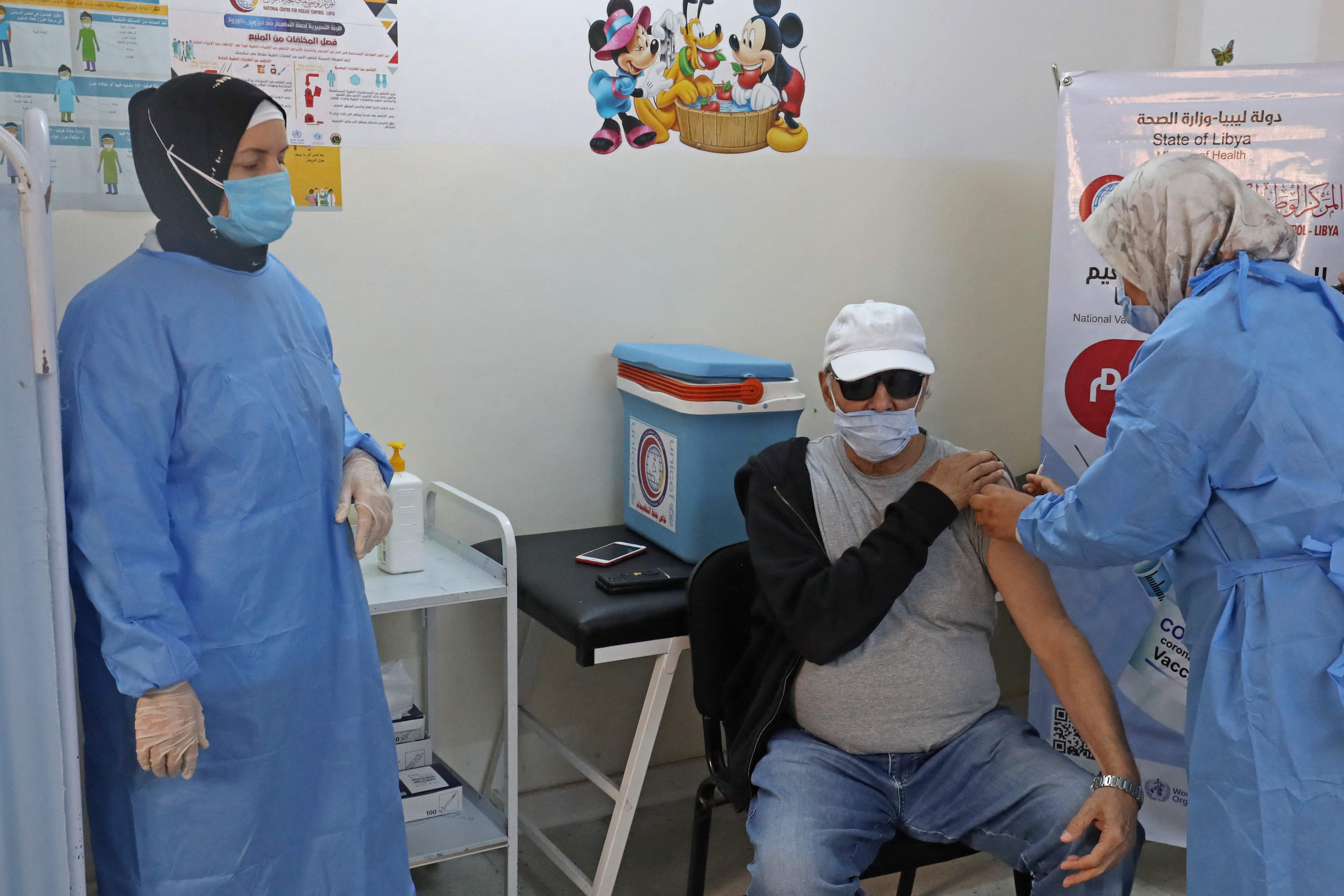 Tenaga kesehatan menyuntikkan vaksin covid-19 kepada warga di Tripoli, Libia.