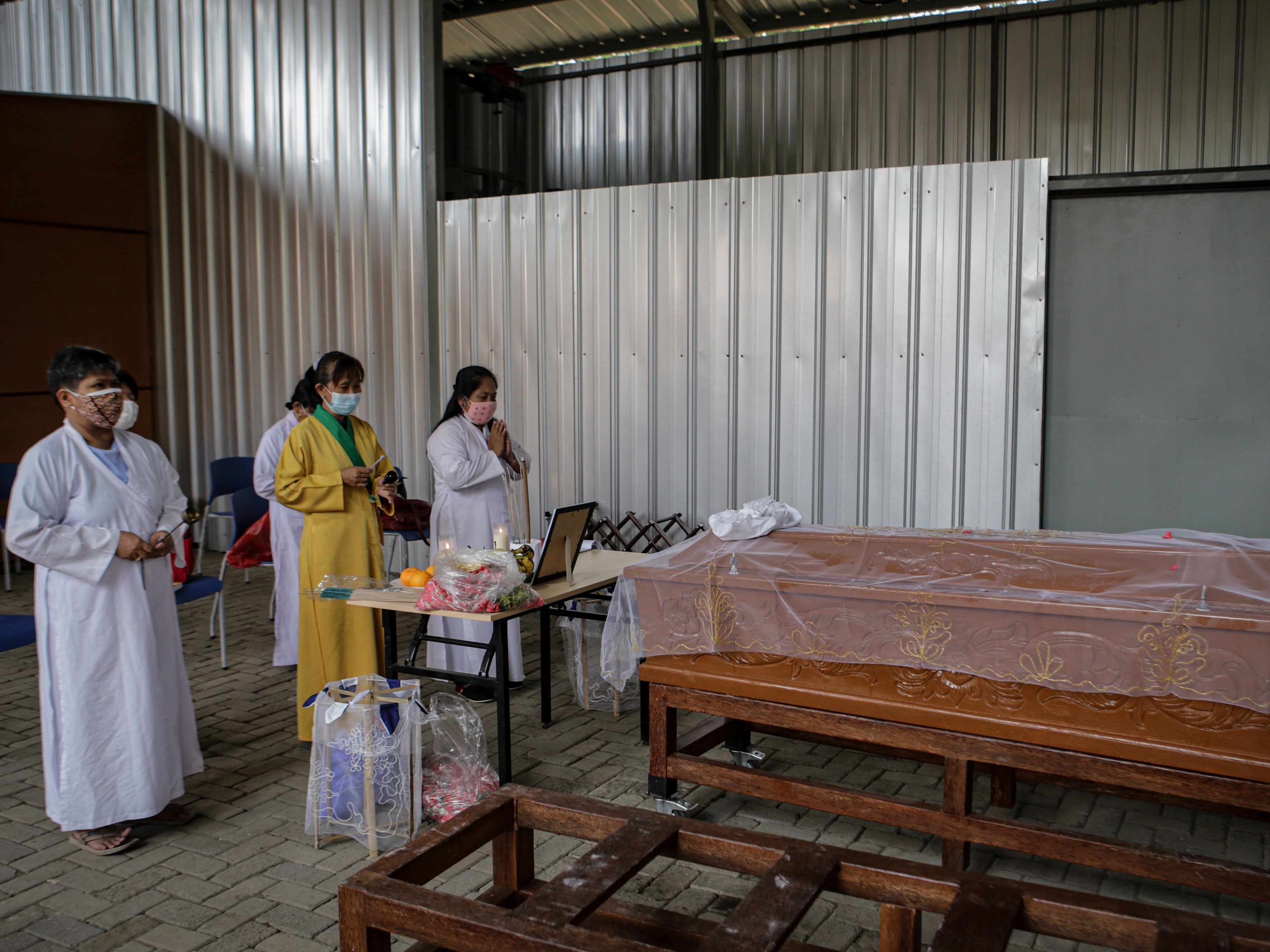 Sejumlah kerabat mendoakan jenazah covid-19 sebelum dikremasi di TPU Tegal Alur, Jakarta, Jumat (30/7).
