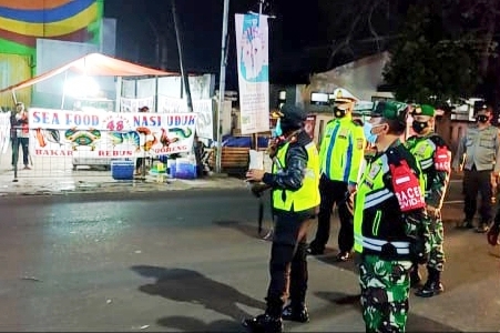  Anggota polisi didampingi TNI mengimbau pedagang kuliner di sekitar kawasan Lembang Kabupaten Bandung Barat mematuhi aturan PPKM Darurat.